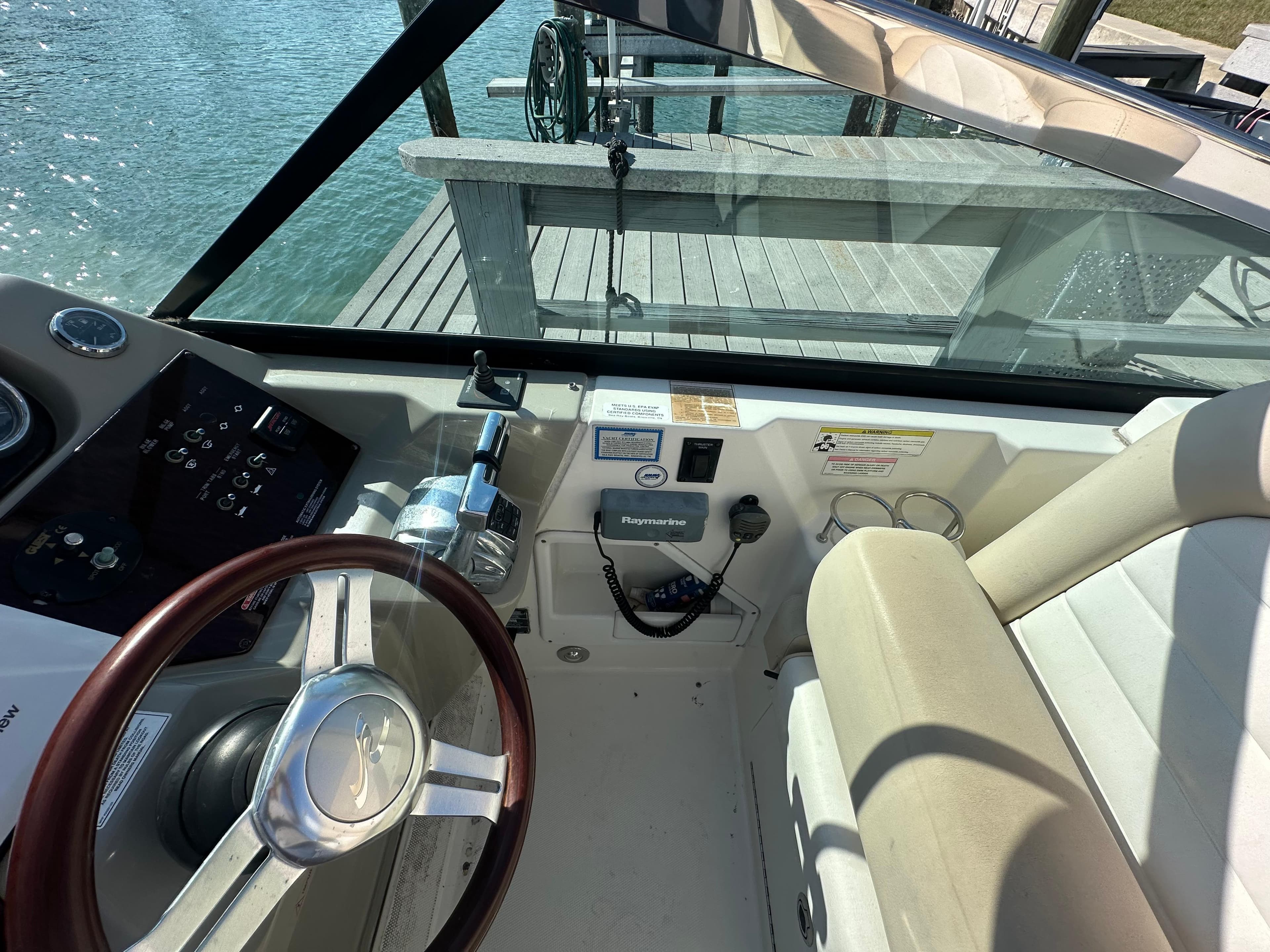 2013 Sea Ray 370 Venture helm with steering wheel and control panel, dockside view.