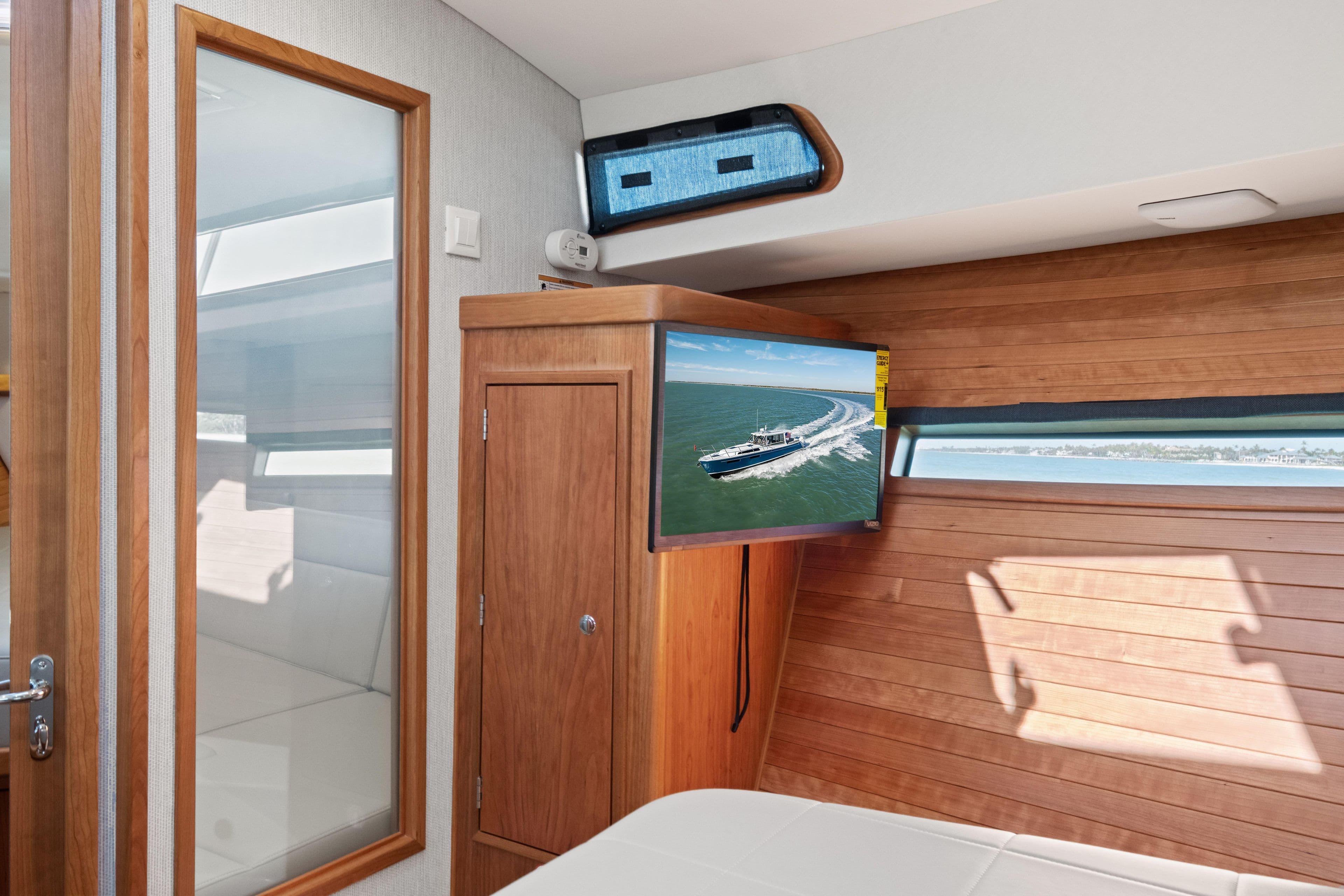 Interior of 2026 MJM 47 R yacht with wood paneling and mounted TV.