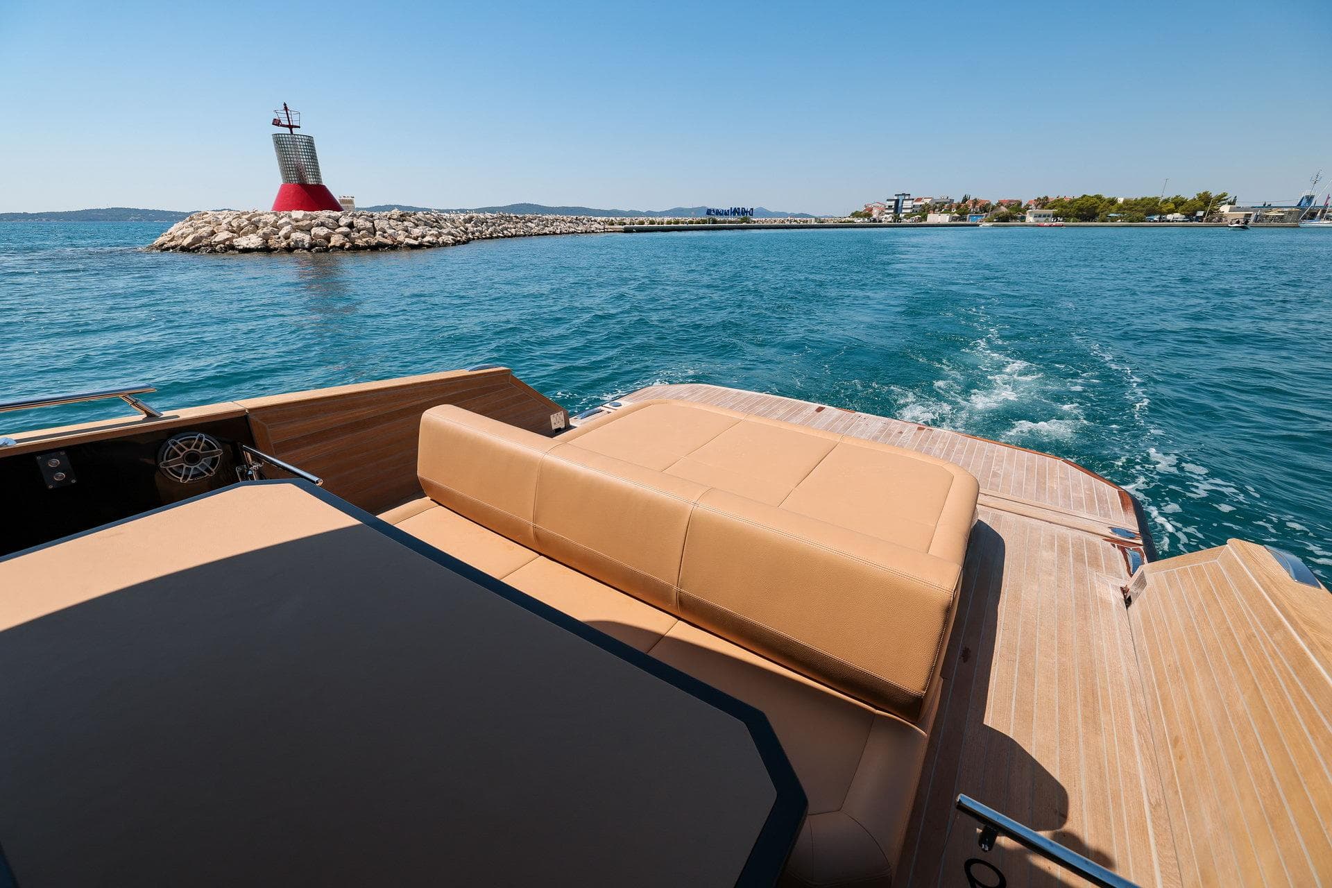 2025 Focus Forza 37 yacht cruising near a lighthouse on a sunny day.