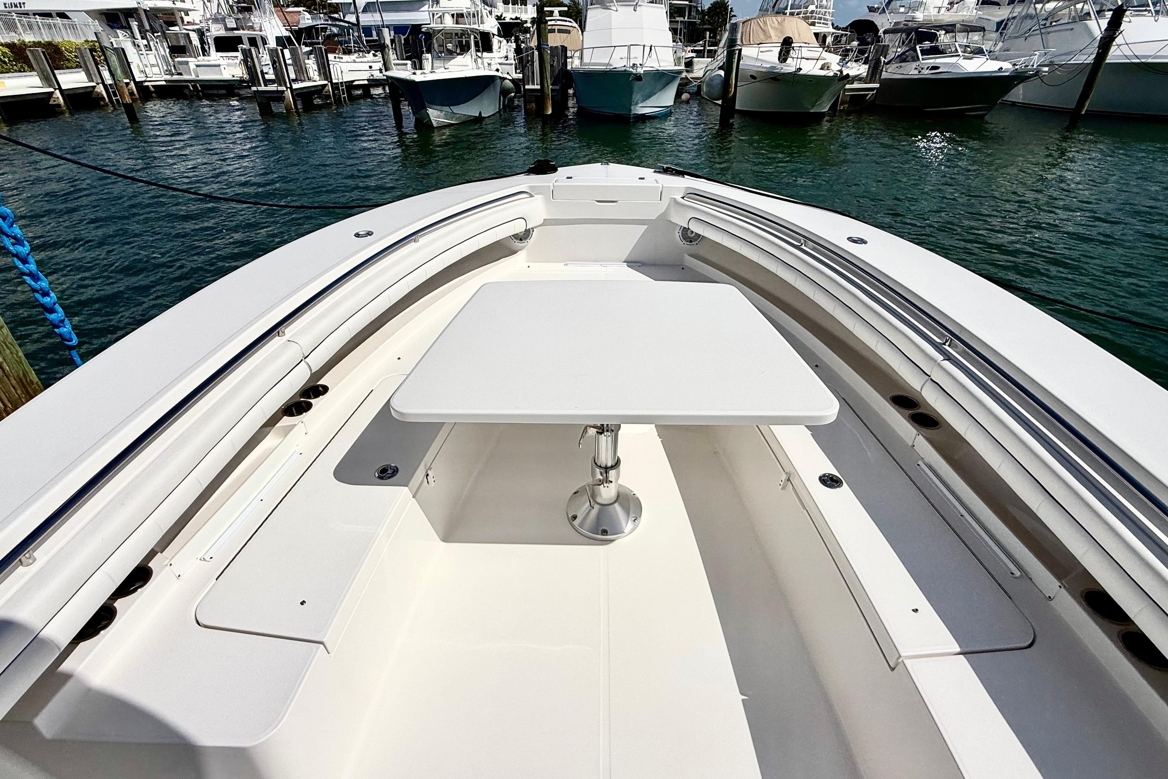 2016 Regulator 34SS boat with a spacious deck and table, docked at a marina.