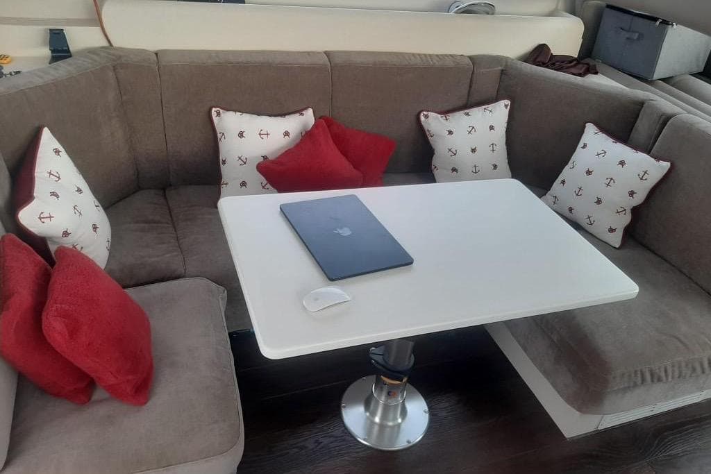 Cozy seating area on 2005 Mochi Dolphin 51 yacht with cushions and table.