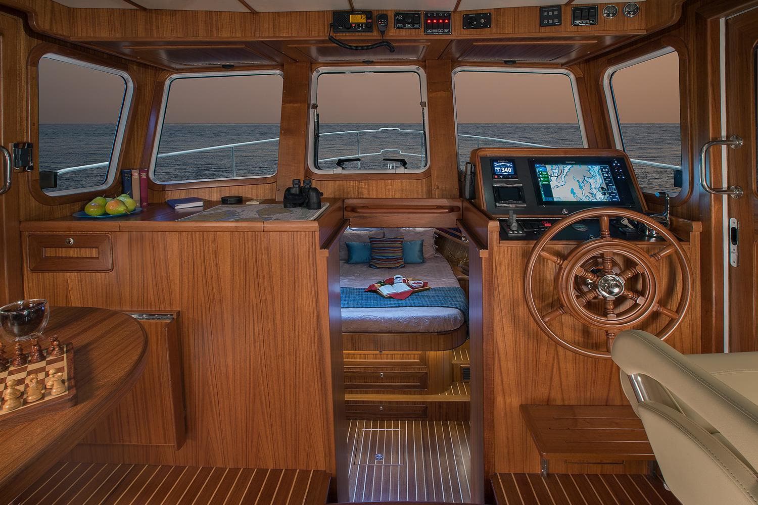 2025 Helmsman Trawlers 38E Pilothouse interior with wooden finish and navigation equipment.