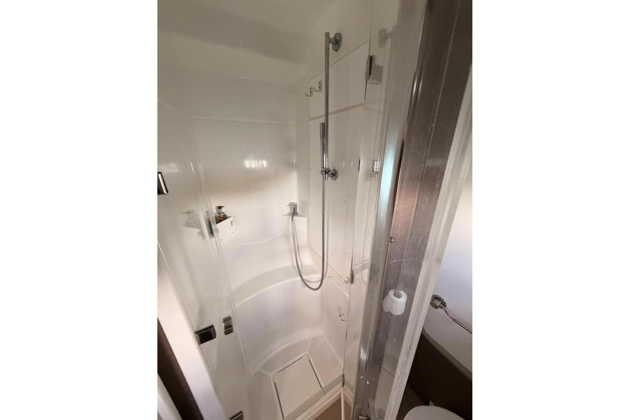 Compact shower area in a 2020 Bali 5.4 model, featuring modern fixtures and white interior.