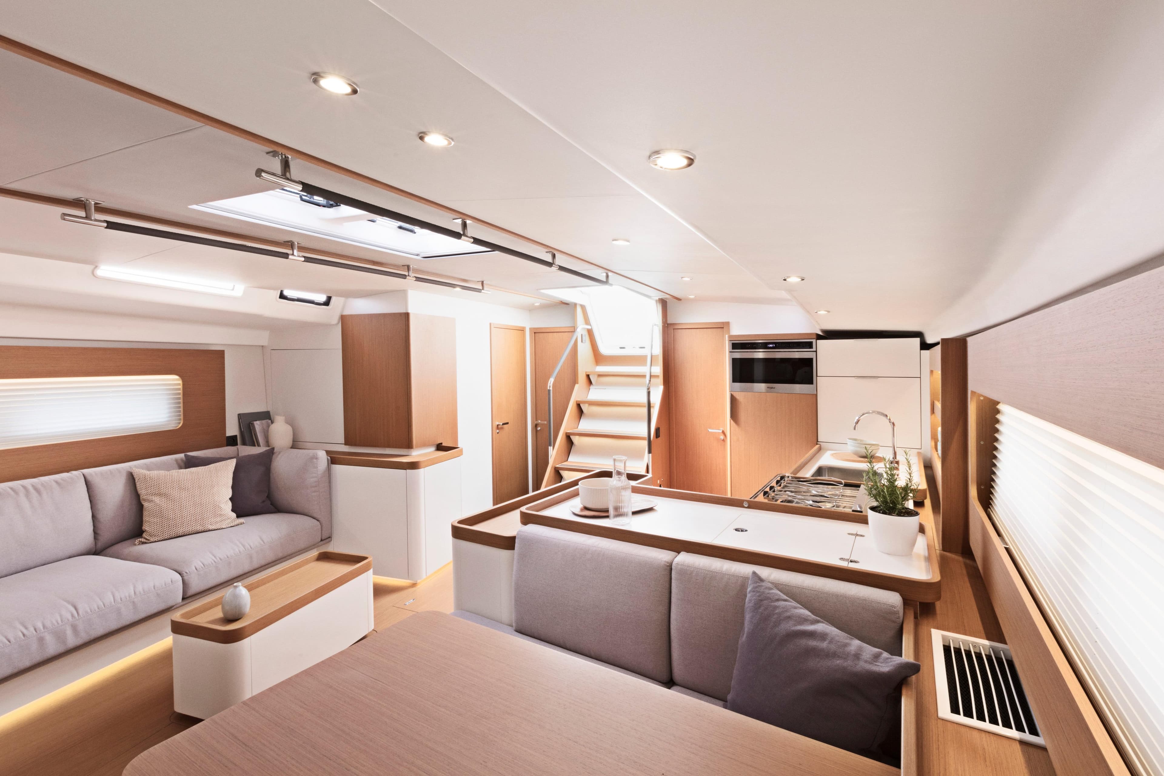 Luxurious interior of 2026 Beneteau First 53 yacht, featuring modern kitchen and comfortable seating.