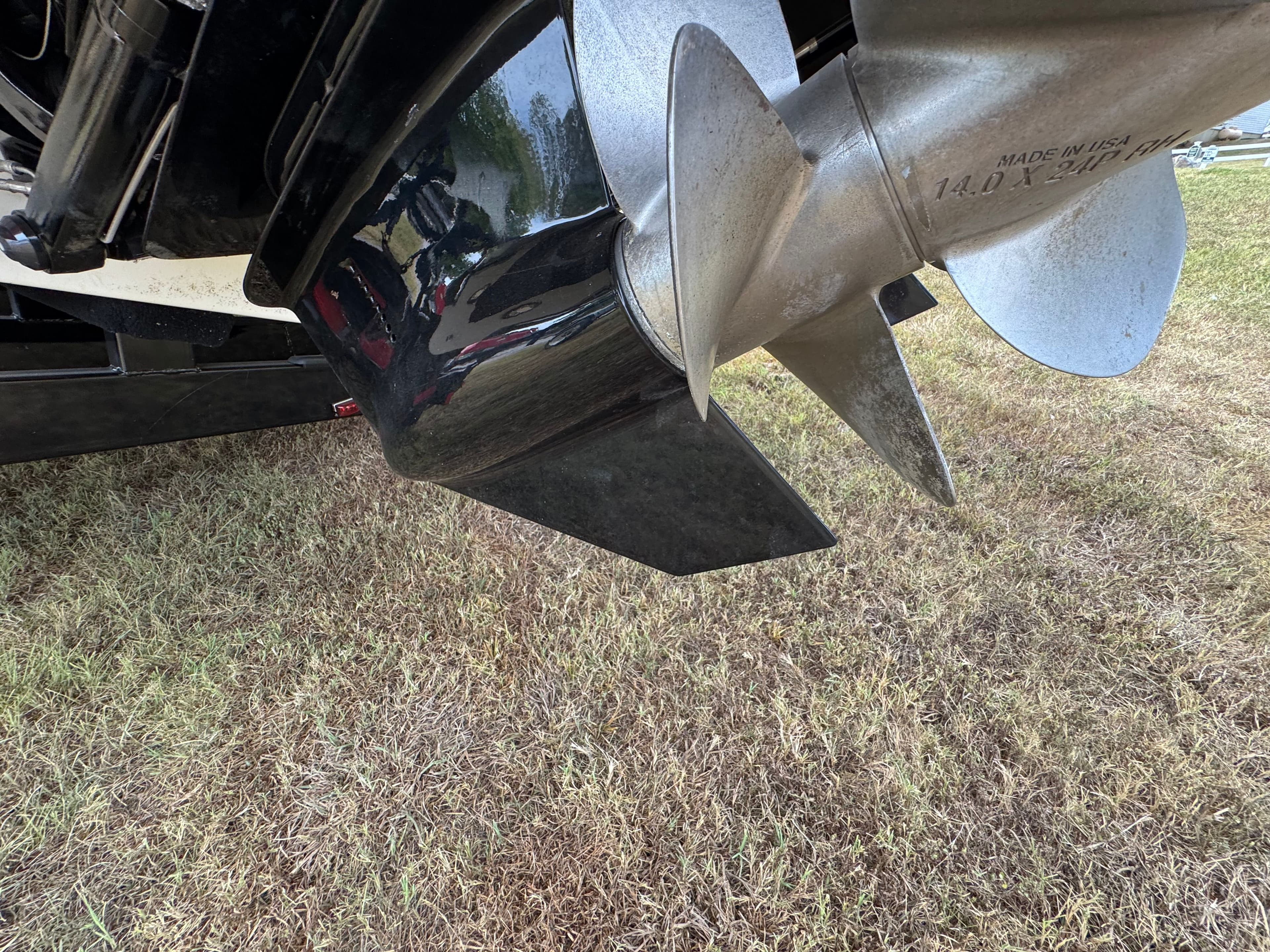 Close-up of a 2022 Sea Ray SLX 310 boat propeller on grass.