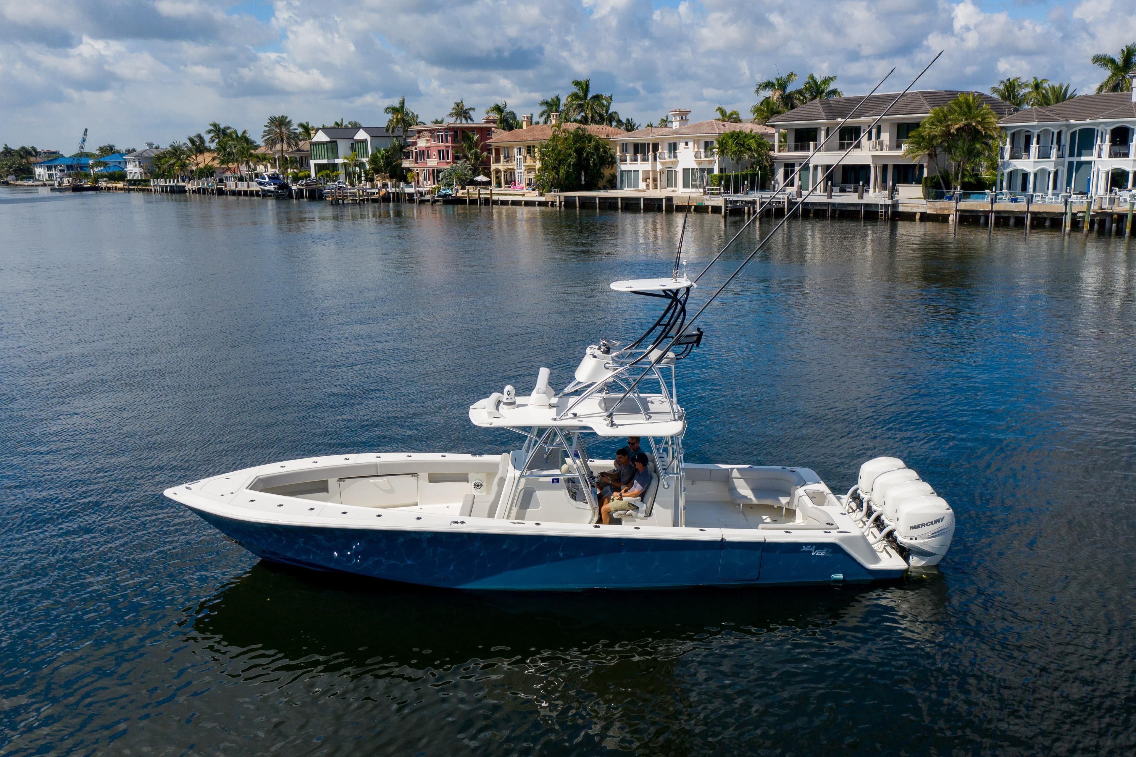 2021 SeaVee 390Z boat on calm water, with luxury waterfront homes in the background.