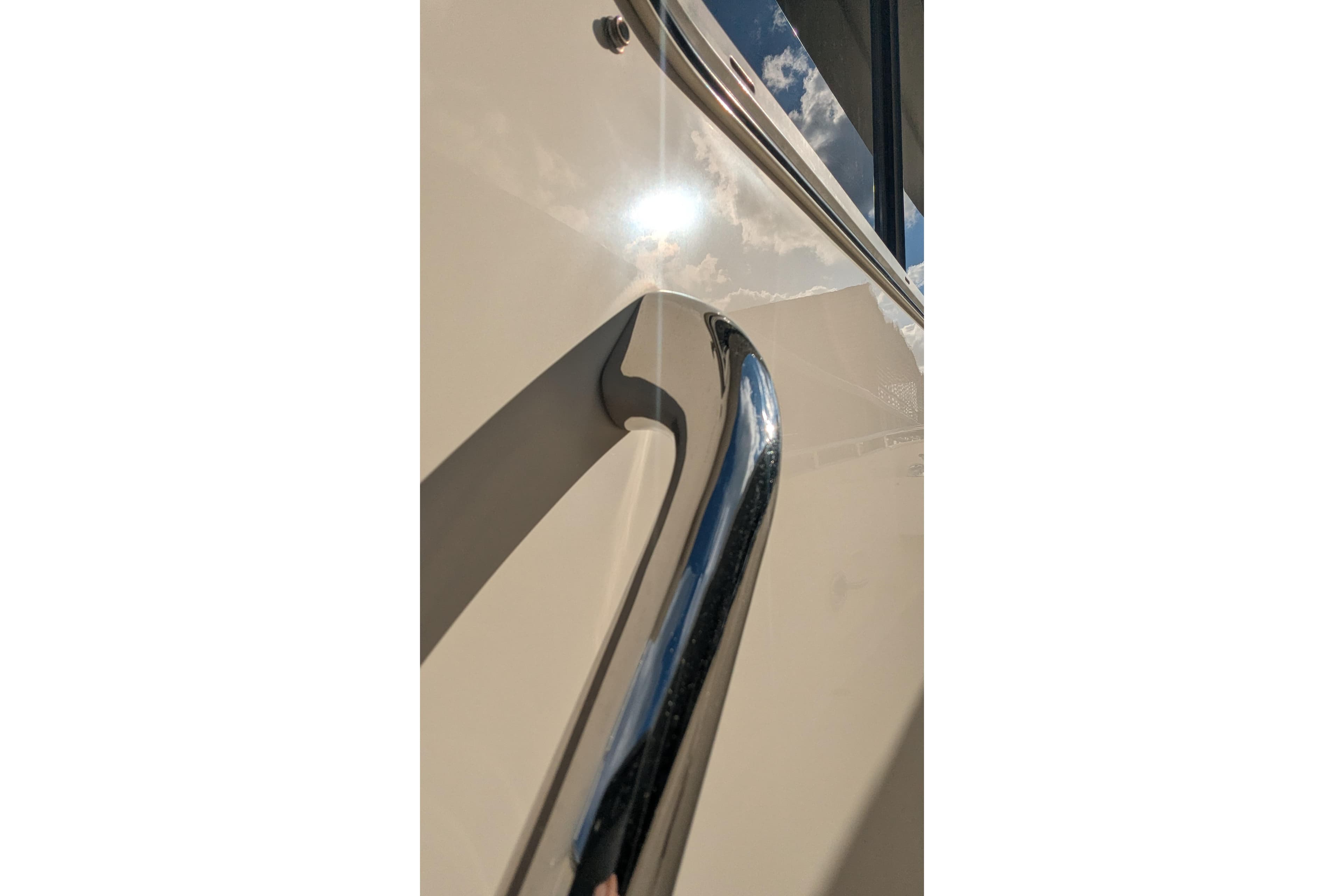 Close-up of 2005 Kadey-Krogen Pilothouse yacht railing reflecting sunlight.