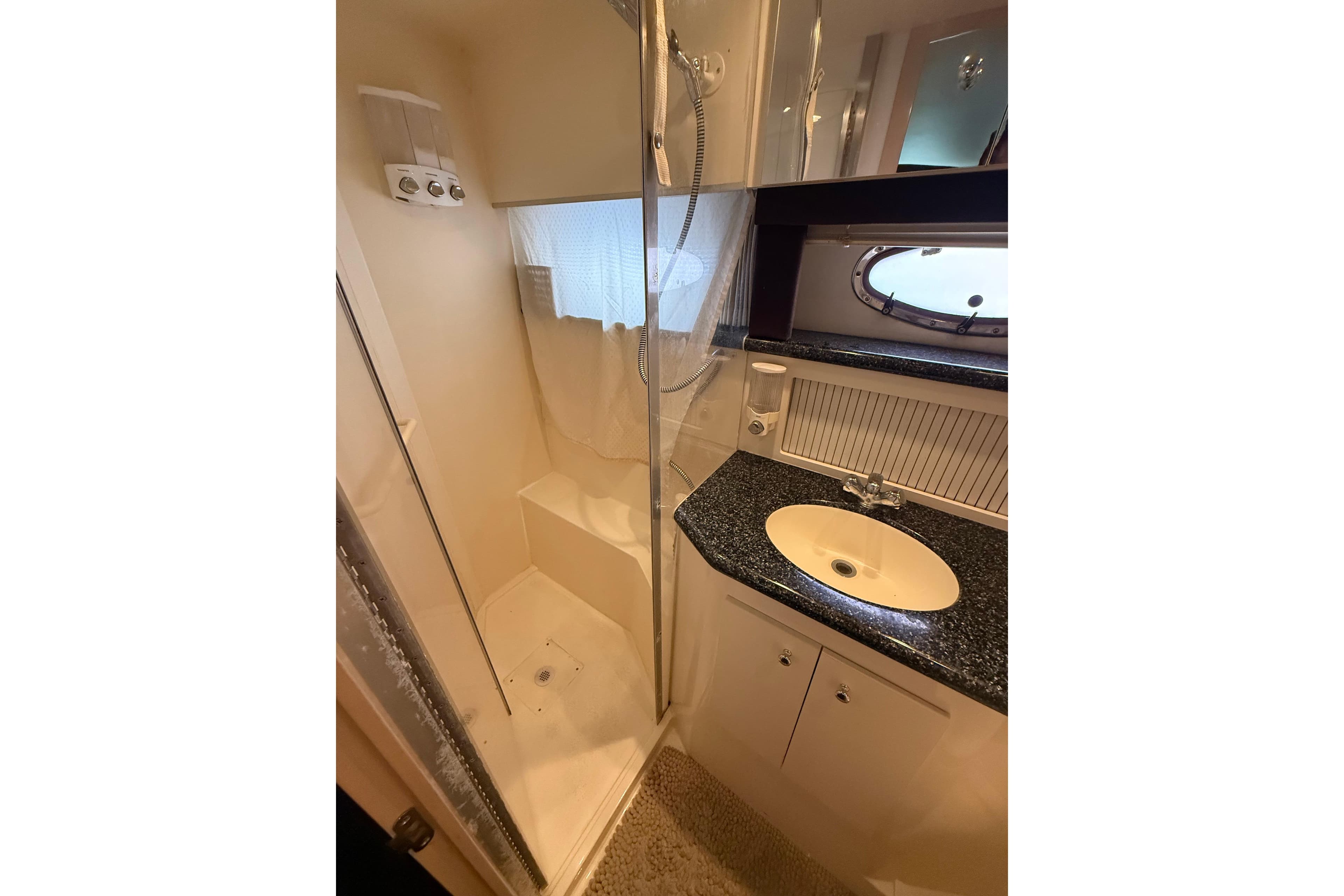 Bathroom interior of 1999 Carver 406 Aft Cabin Motor Yacht with shower and sink.