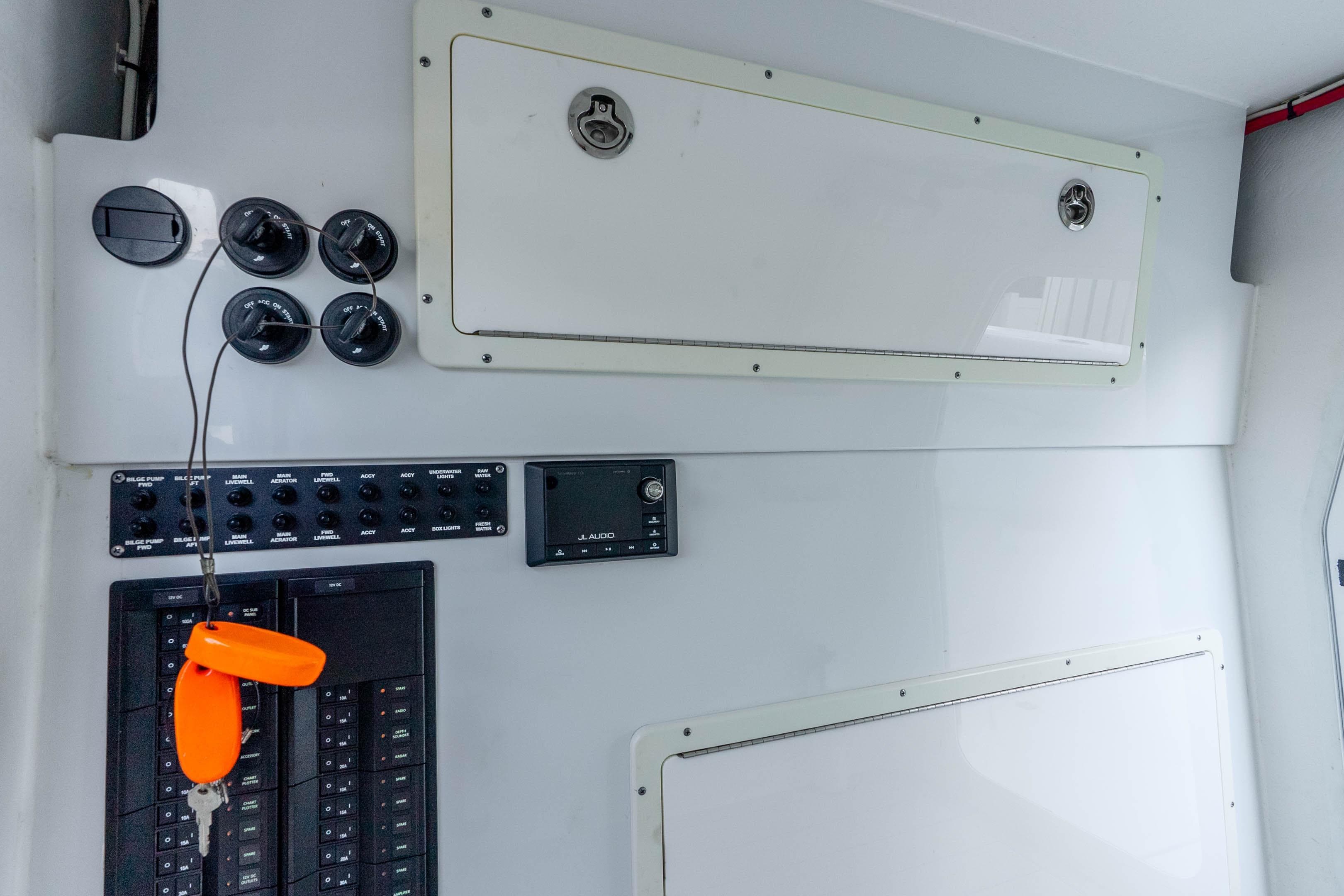 Control panel of a 2019 Freeman 42LR boat with switches and storage compartments.