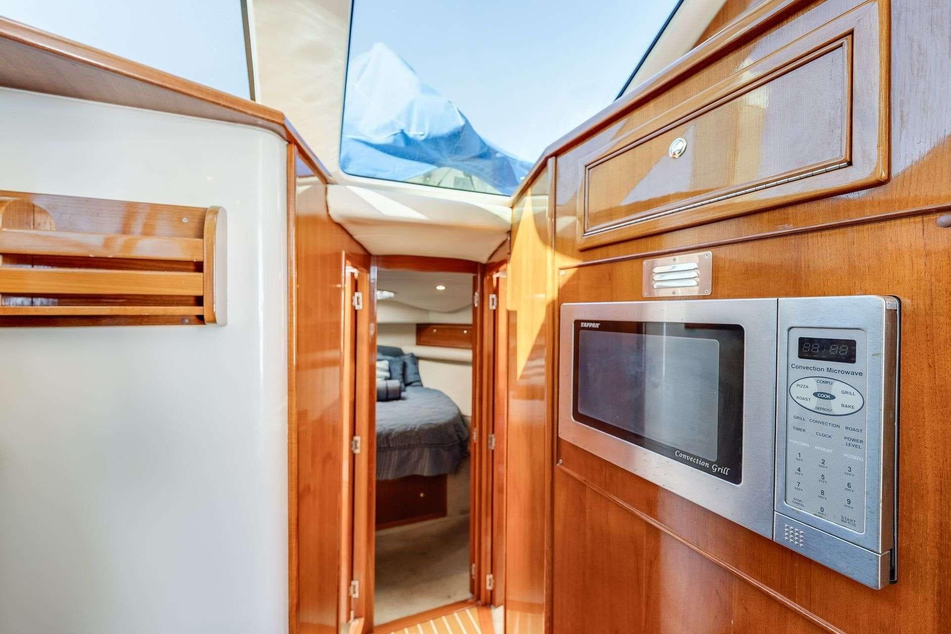 Interior of 2004 Riviera Convertible yacht with wood finish and built-in microwave.