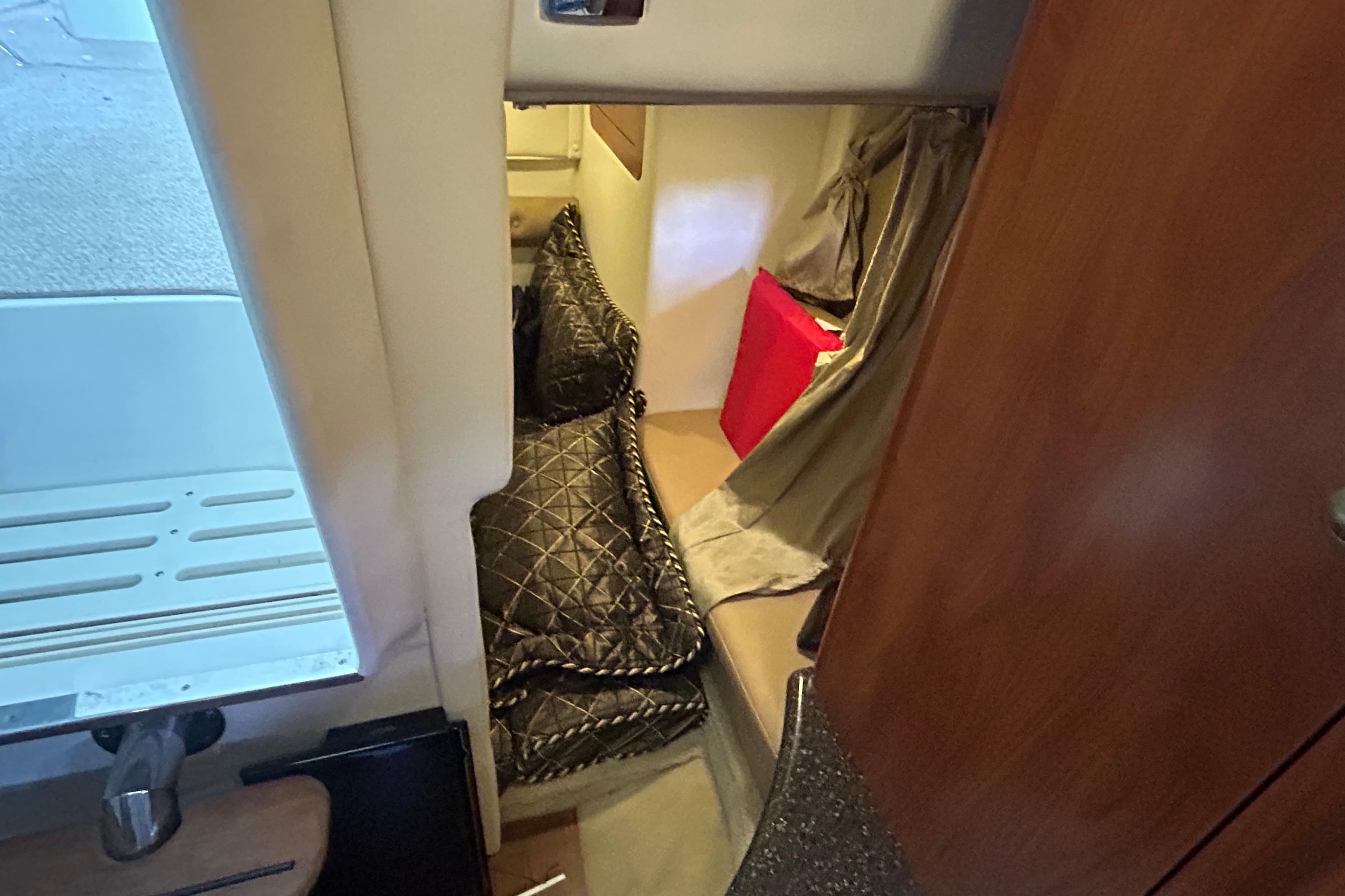 2013 Rinker 310 Express Cruiser cabin interior with cozy bedding and wooden accents.