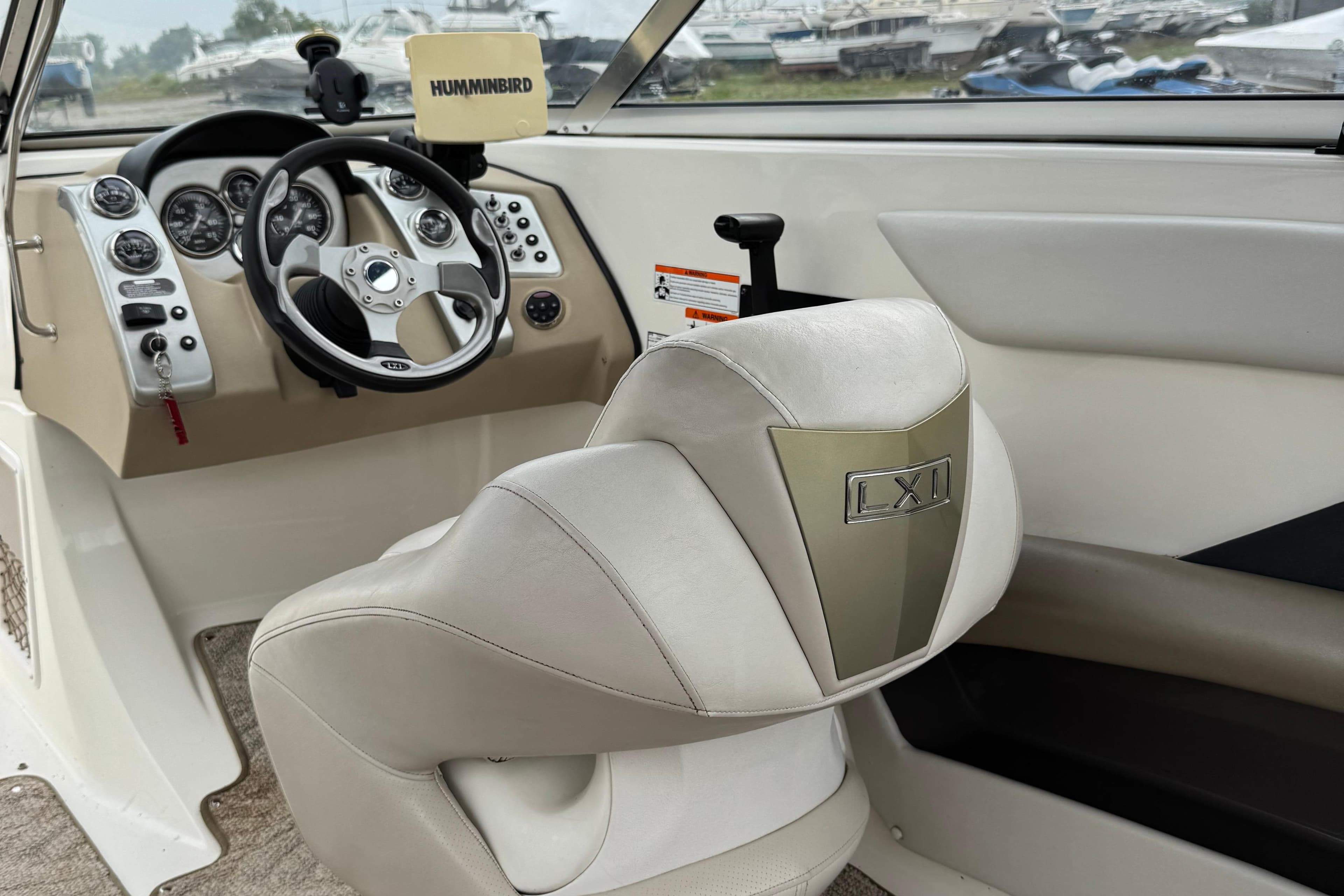 Interior of a 2006 Larson LXi 228 boat with steering wheel and dashboard controls.