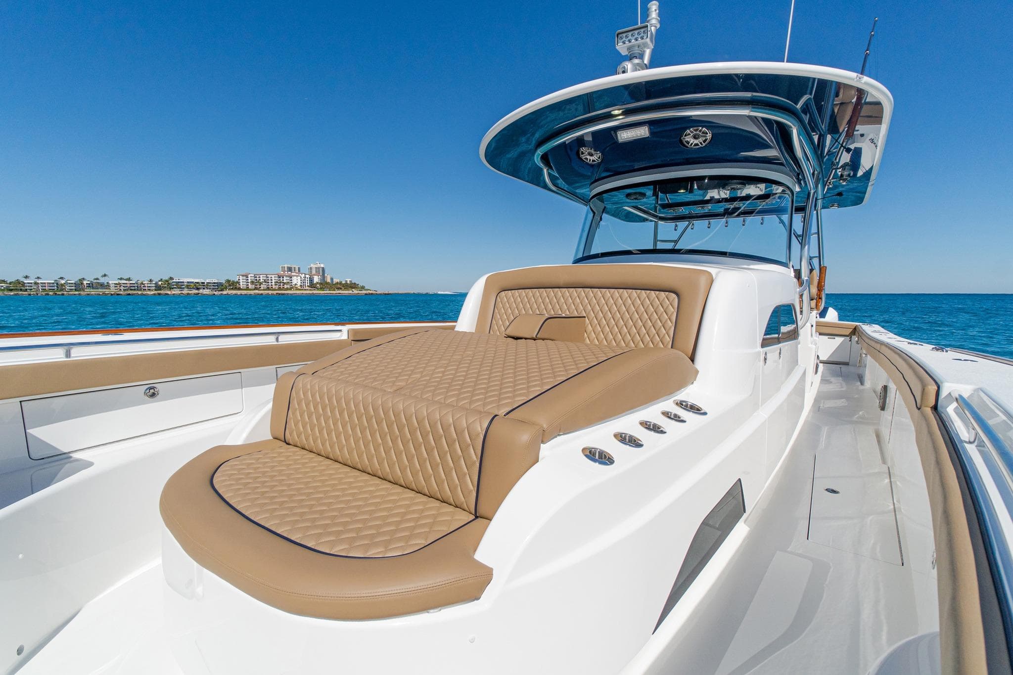 2026 Valhalla Boatworks V-46 luxury yacht with tan seating, cruising on clear blue waters.