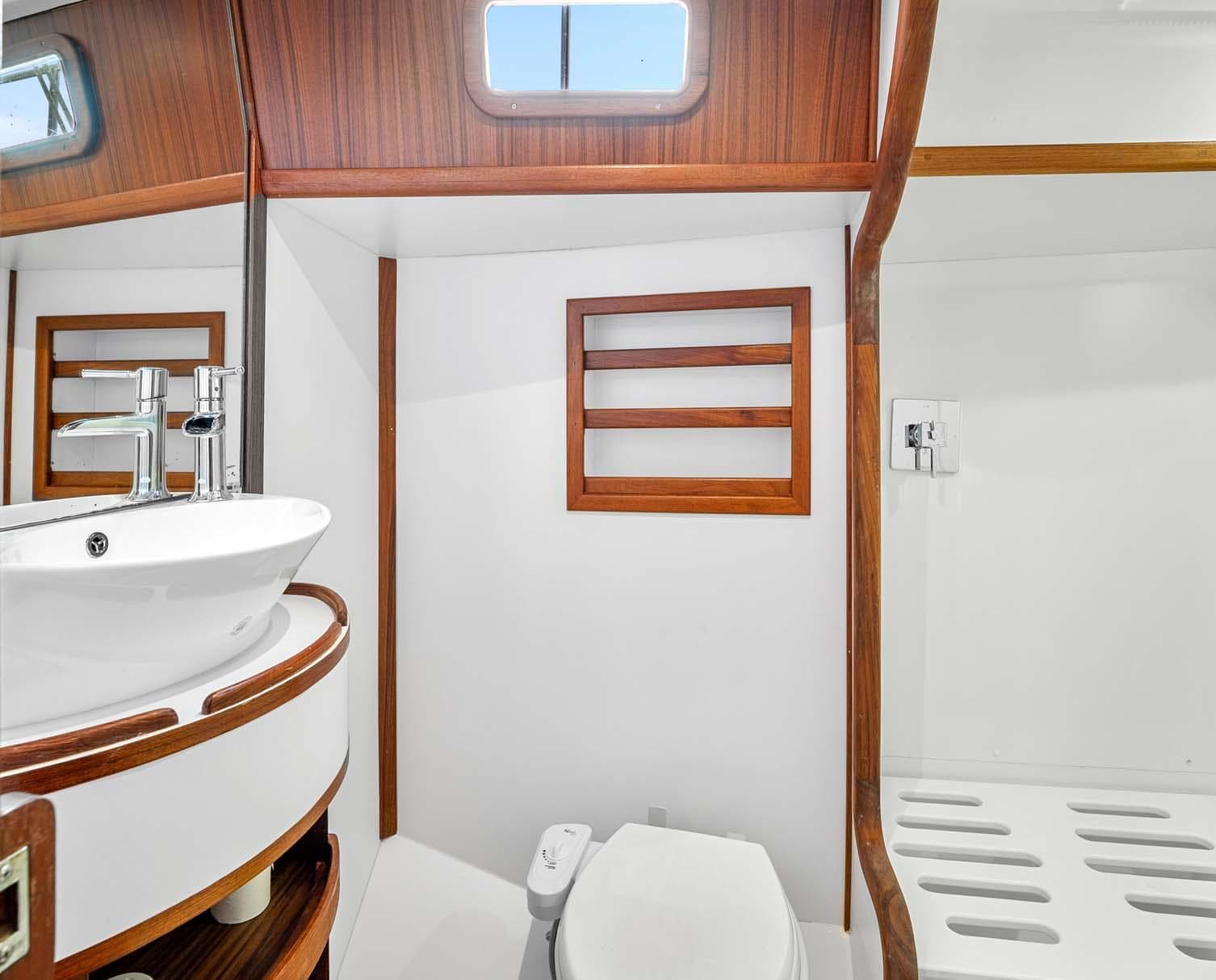 Modern bathroom interior in 1981 Pearson 530 yacht with wood accents and sleek fixtures.