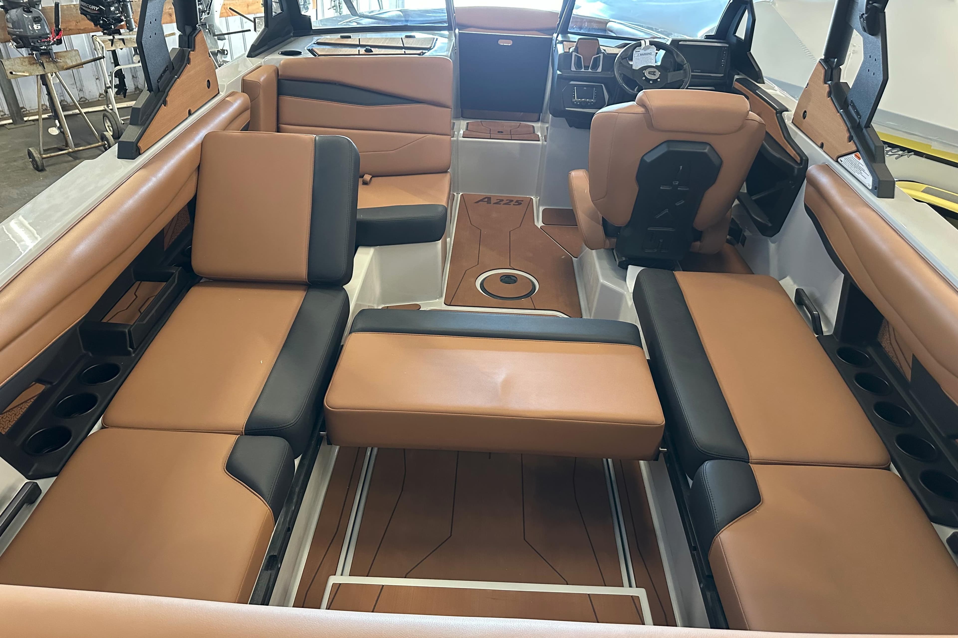 Luxurious interior of 2026 Axis A225 boat with tan and black seating.