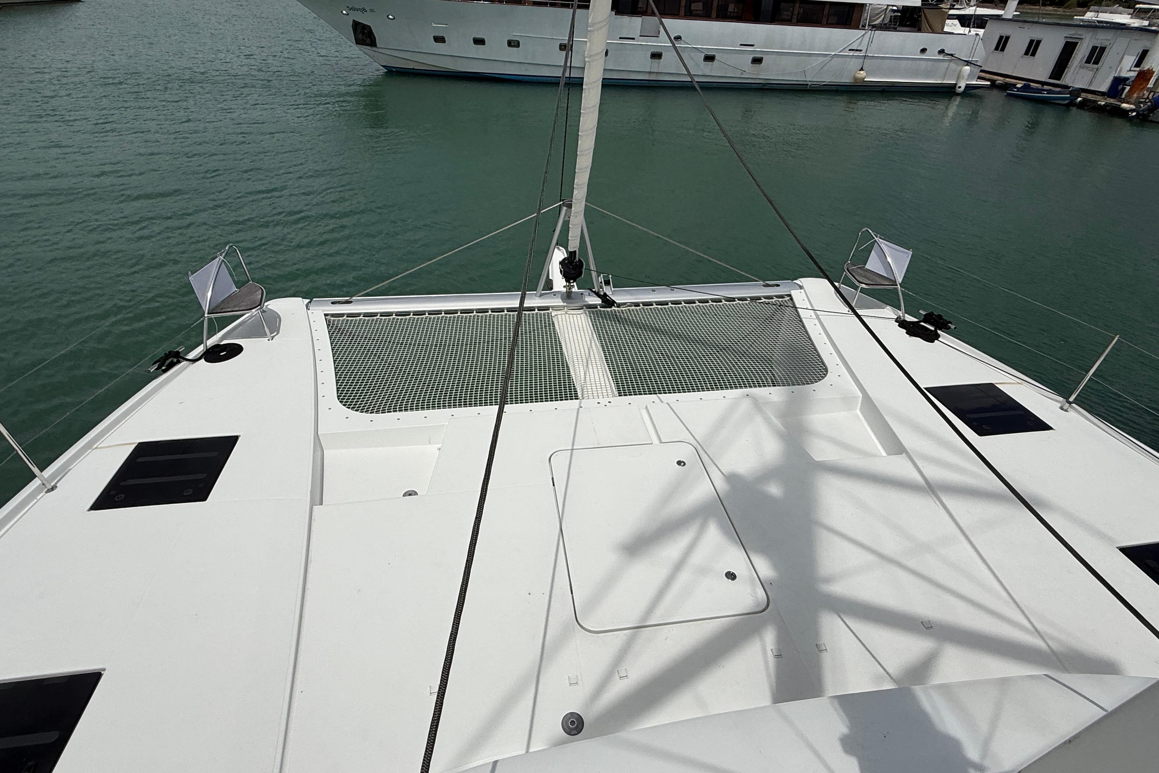 2025 Fountaine Pajot Tanna 47 catamaran deck with netting, docked in marina.