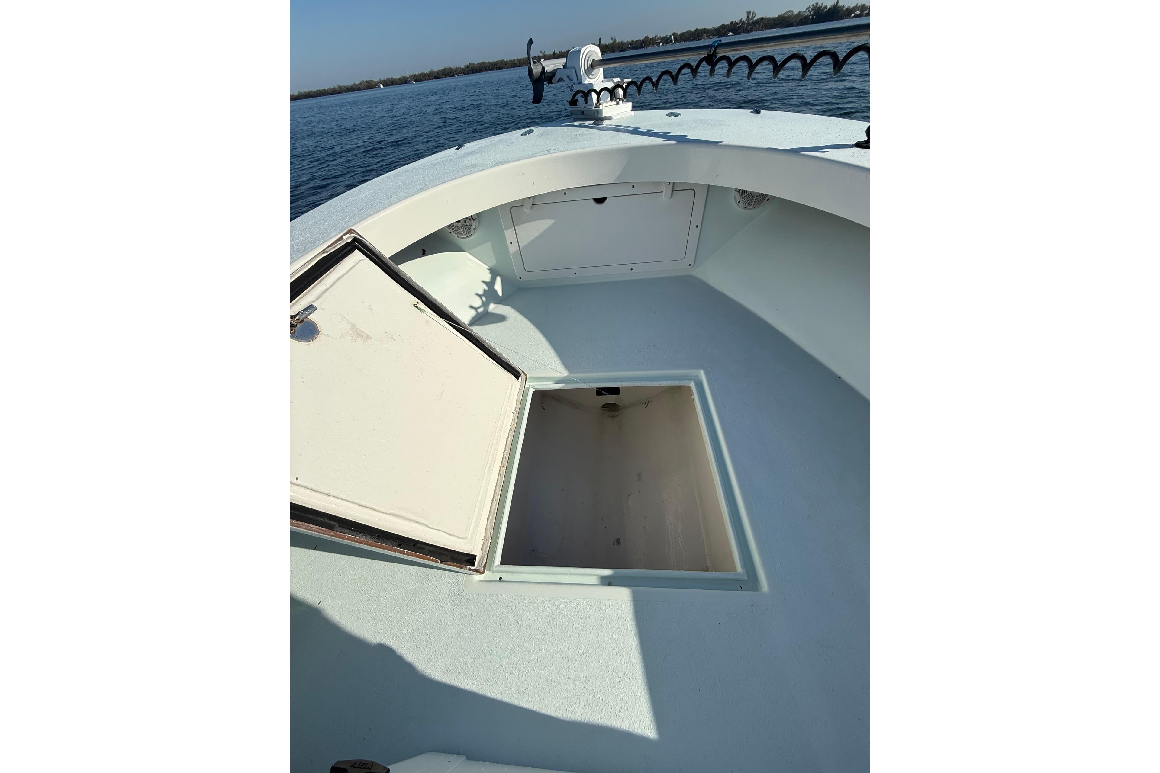 1987 Privateer 22 Roamer boat with open storage compartment on calm water.