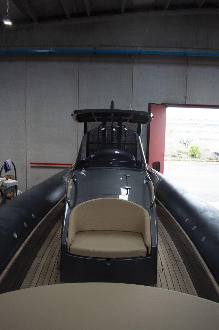 2008 Dariel 12 boat in a garage, featuring sleek design and beige seating.
