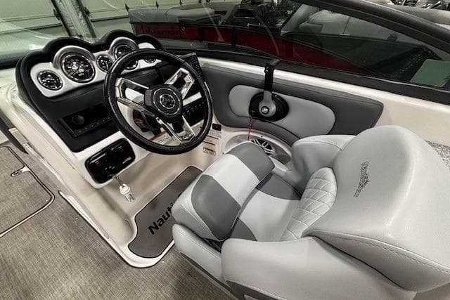 2023 NauticStar 243DC Sport Deck boat interior with steering wheel and cushioned captain's chair.