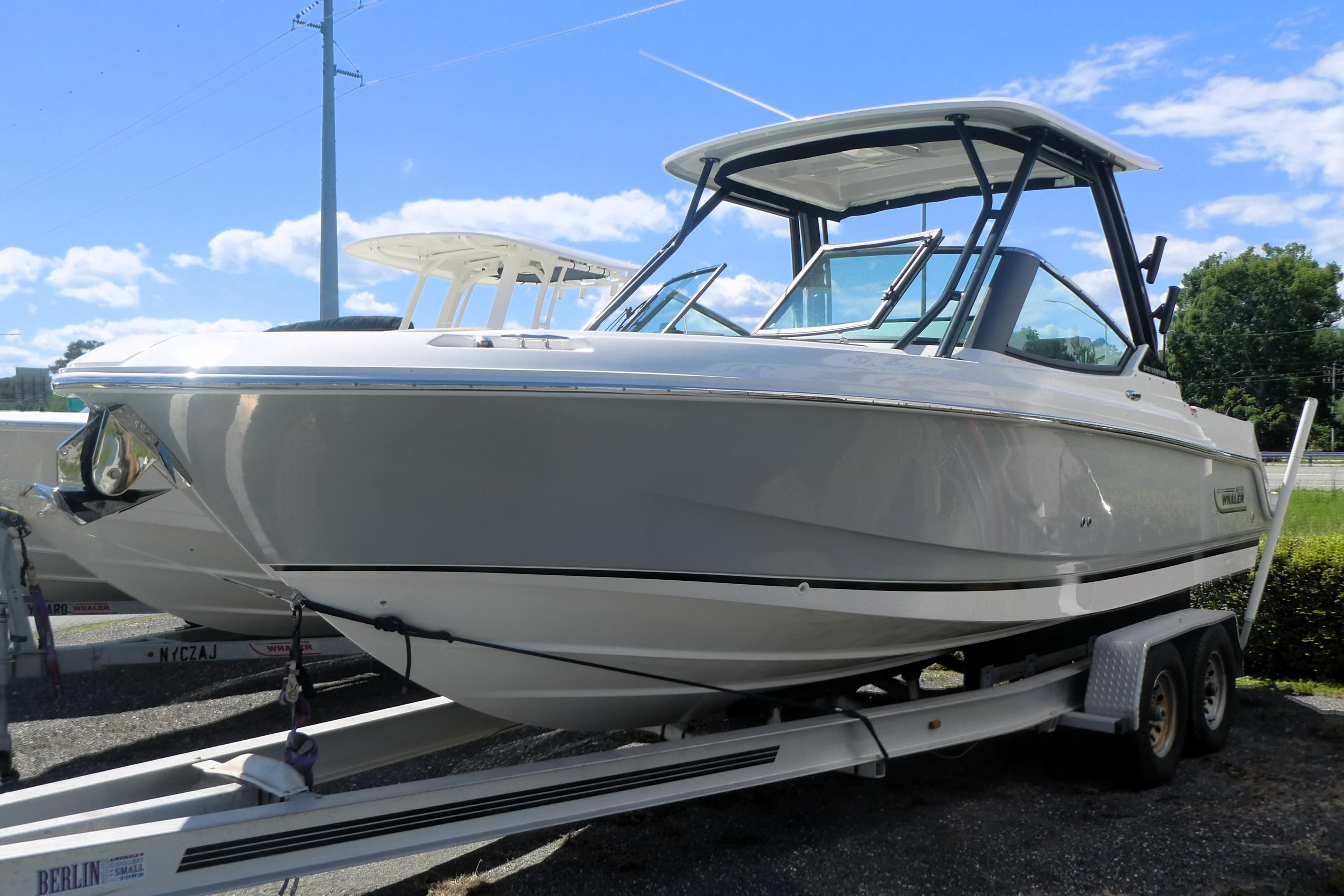 2026 Boston Whaler 240 Vantage boat on trailer under clear blue sky.