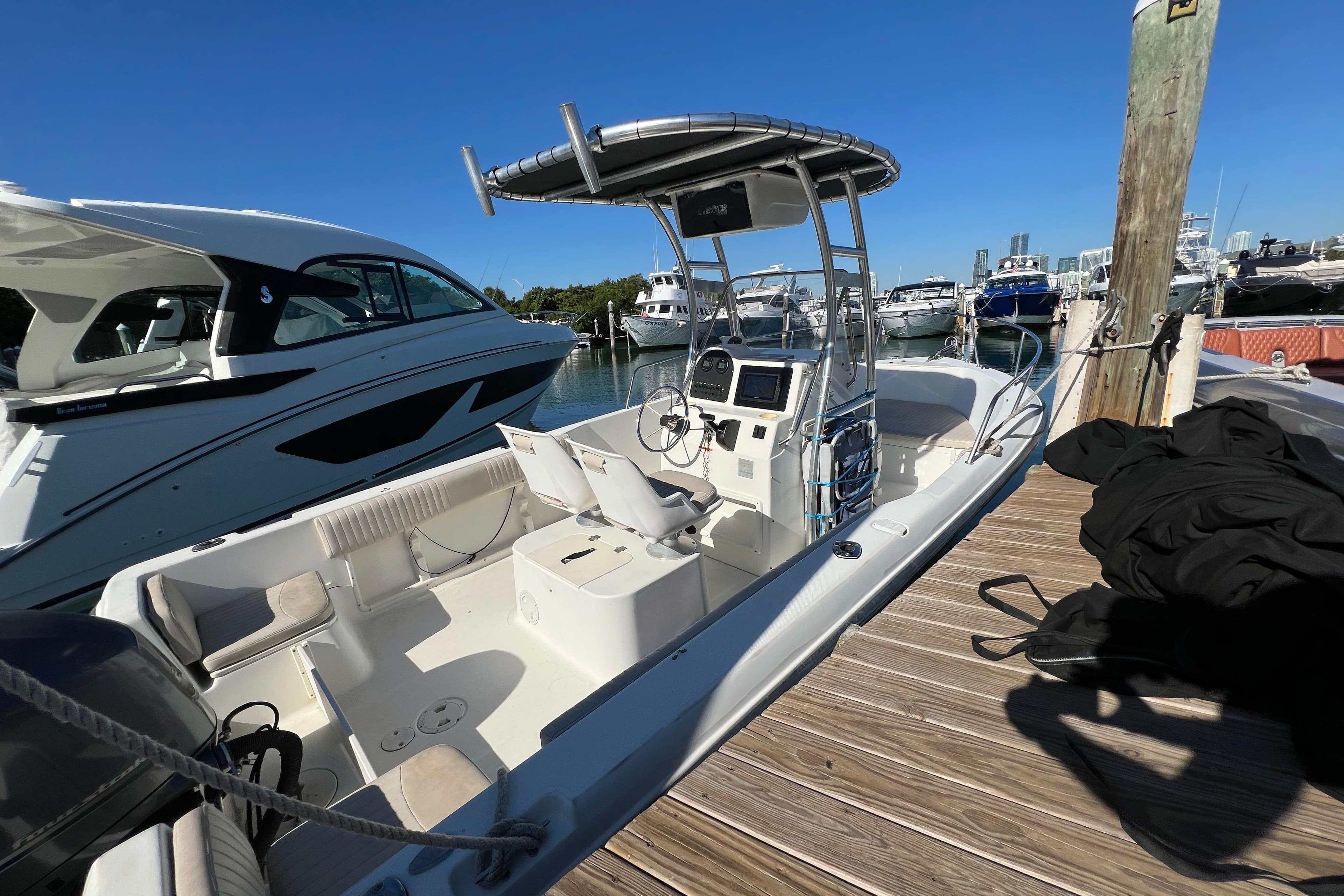 2004 Hydra-Sports 212 CC boat docked at marina, clear blue sky background.