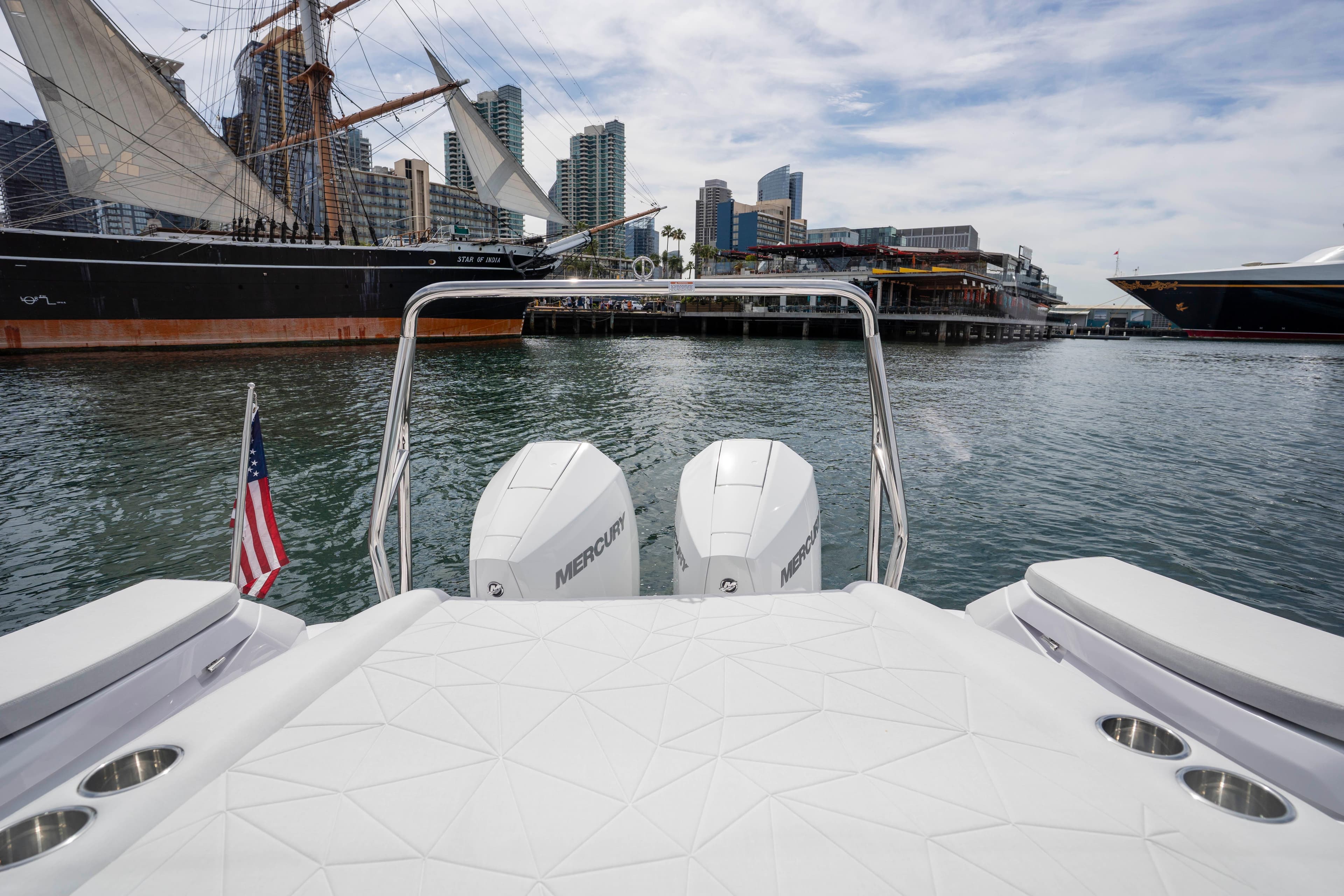 2026 Axopar 29 XC Cross Cabin boat with Mercury engines, docked near a historic ship.