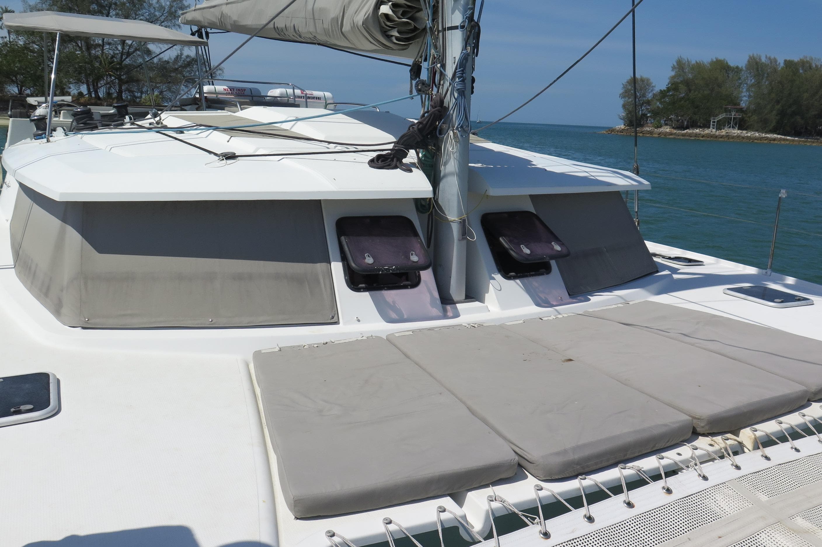 2013 Fountaine Pajot Helia 44 catamaran with sunbathing area, docked by the sea.