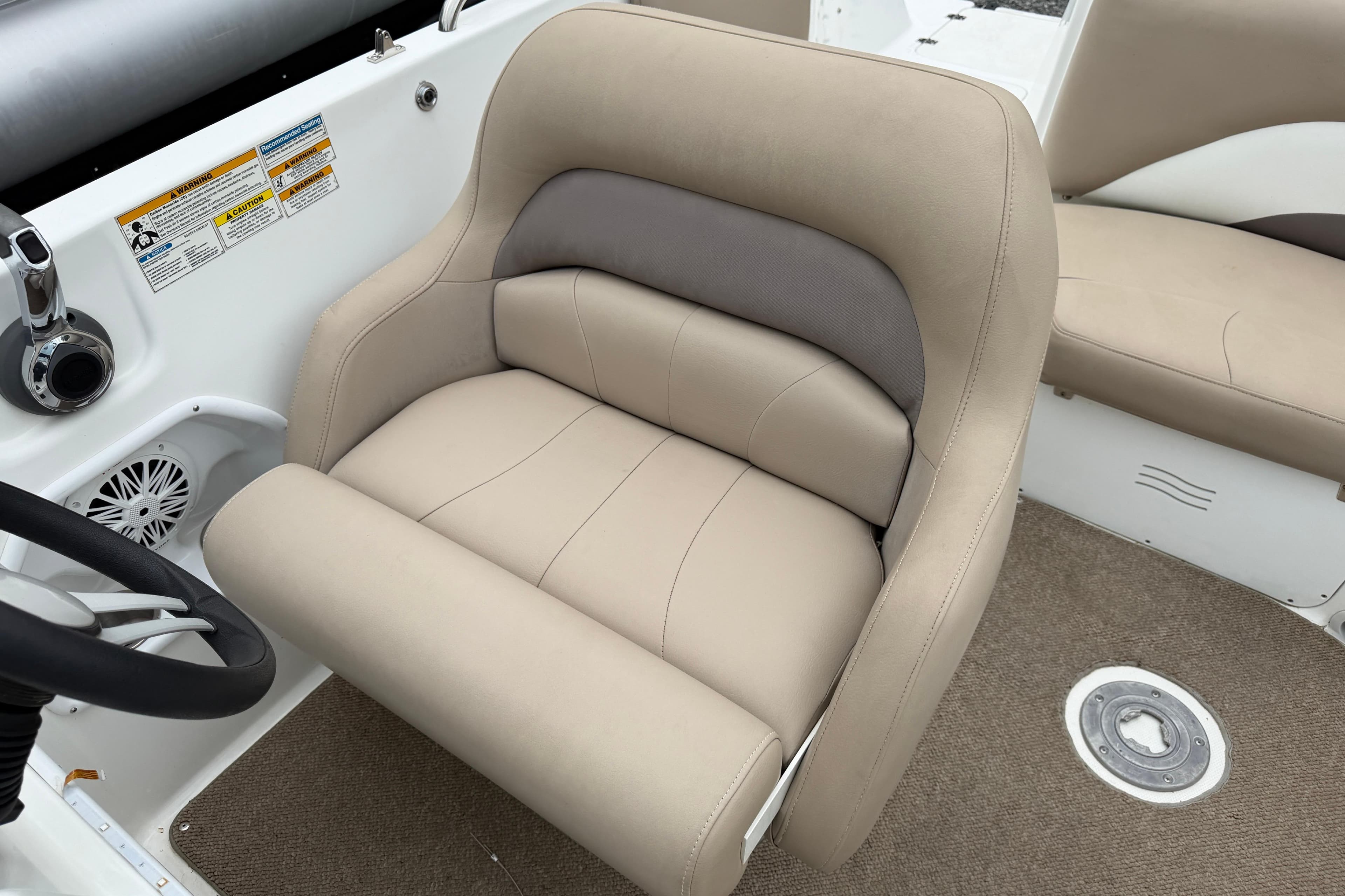 2016 Hurricane SunDeck Sport 202 OB boat interior with beige captain's chair and steering wheel.