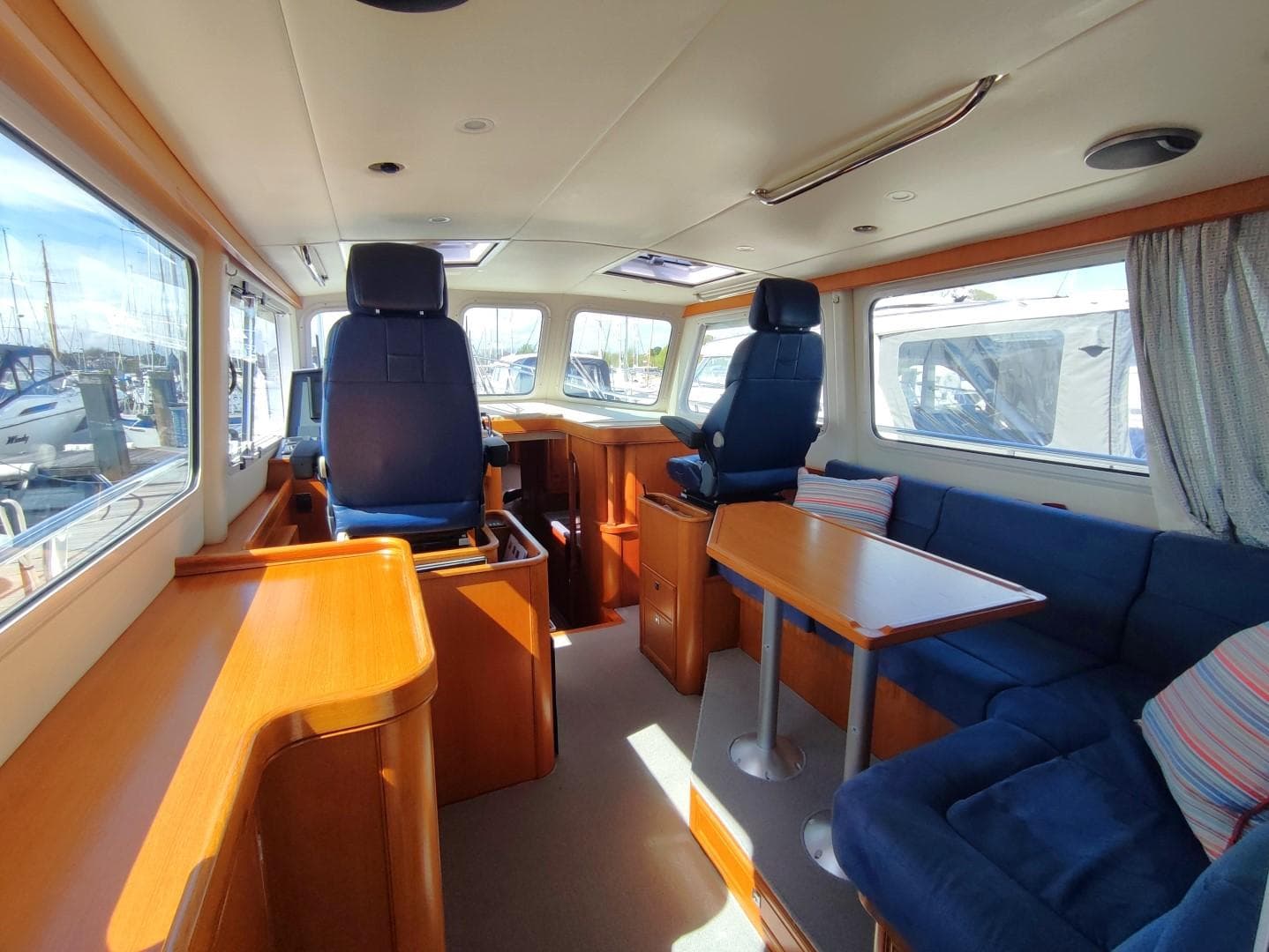 Interior of 2016 Seaward MY-42 yacht with blue seating and wooden furnishings.