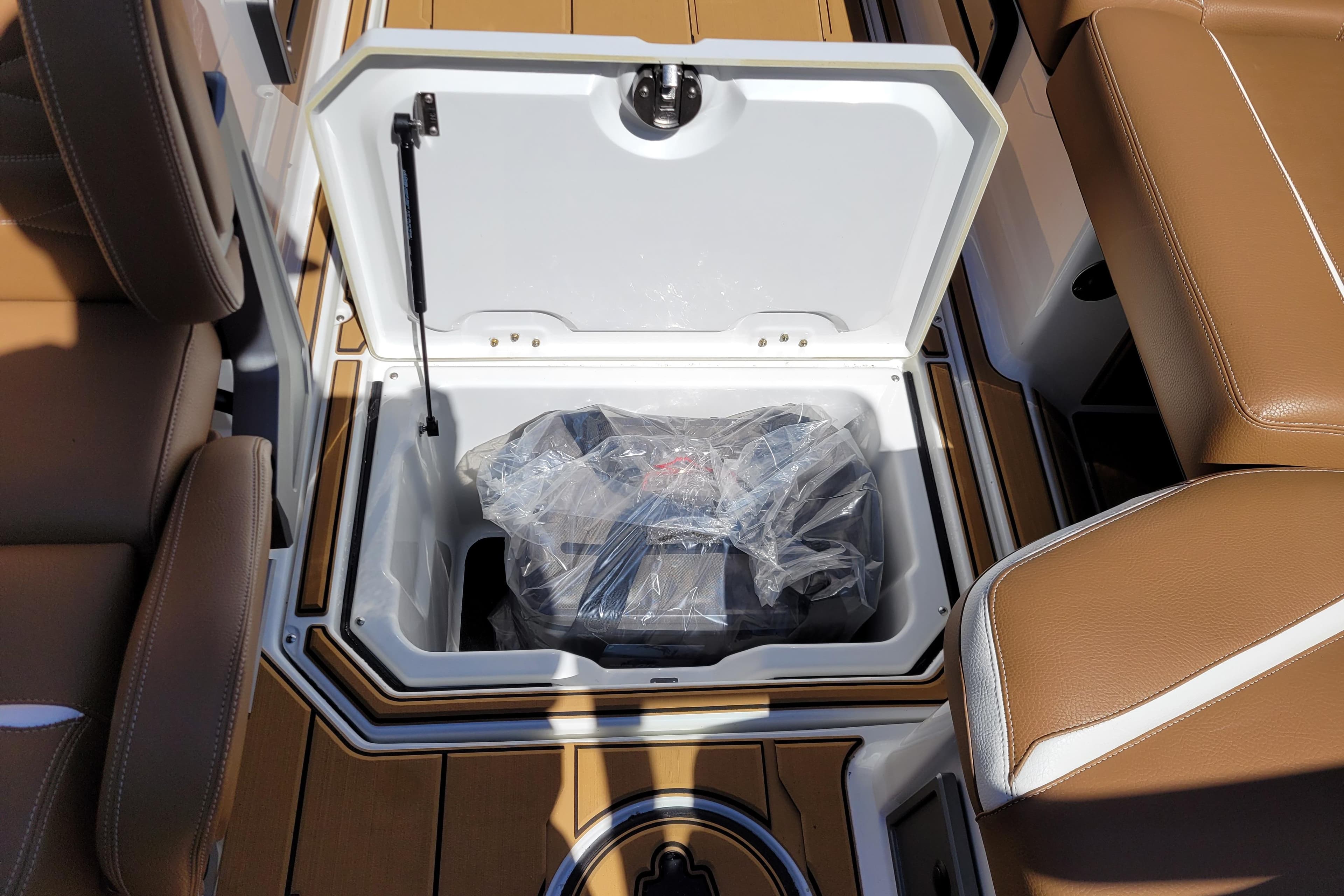 Open storage compartment in 2026 Supra SV 400 boat with brown seating.