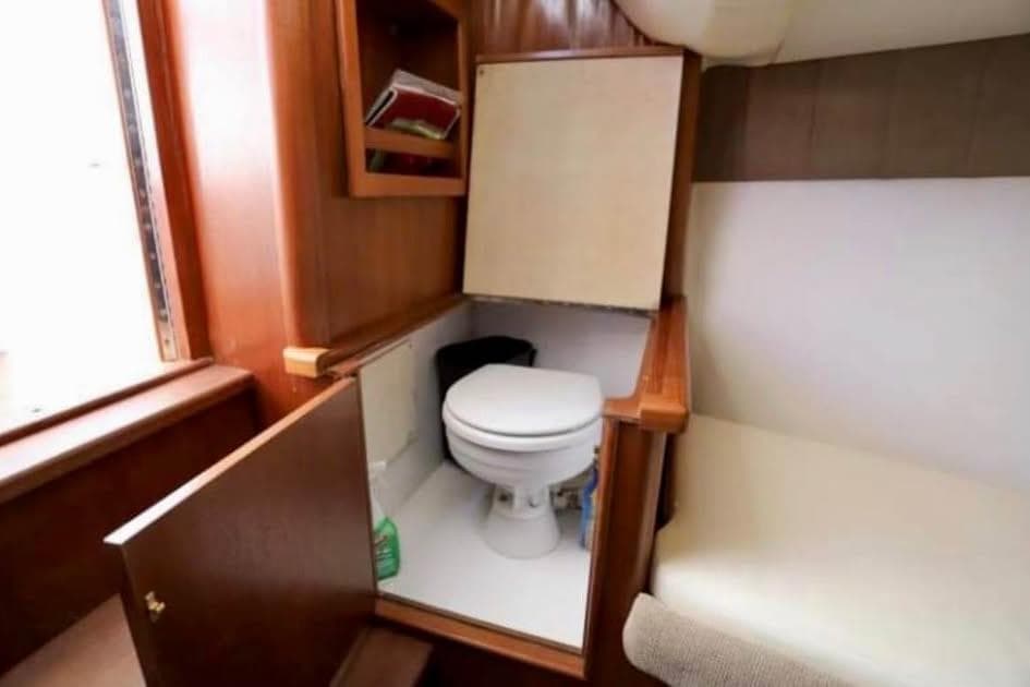 2006 Calyber 29 Express boat interior with compact wooden bathroom and toilet.