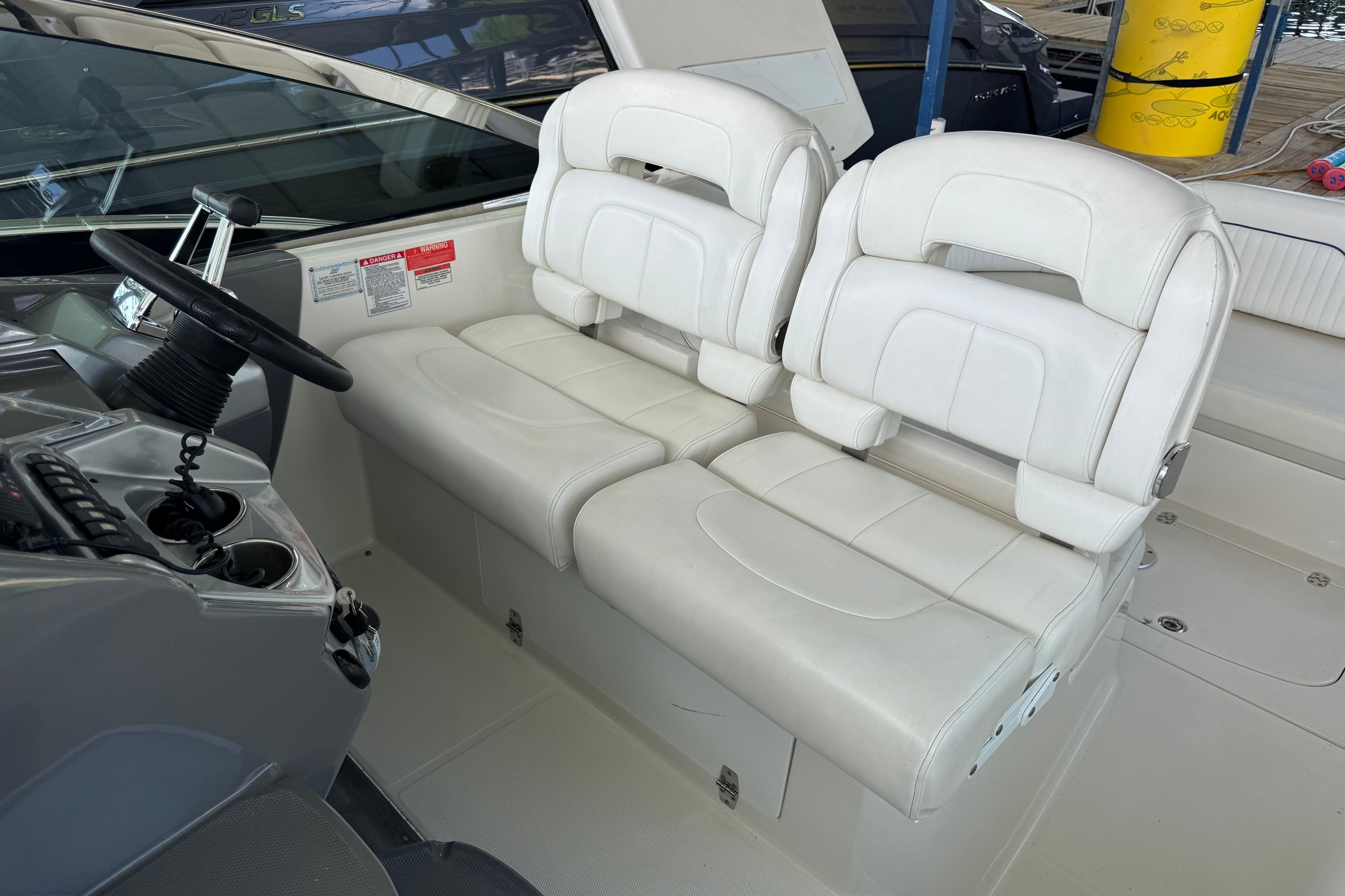 Interior of 2008 Monterey 330 Sport Yacht with white leather seating and helm controls.