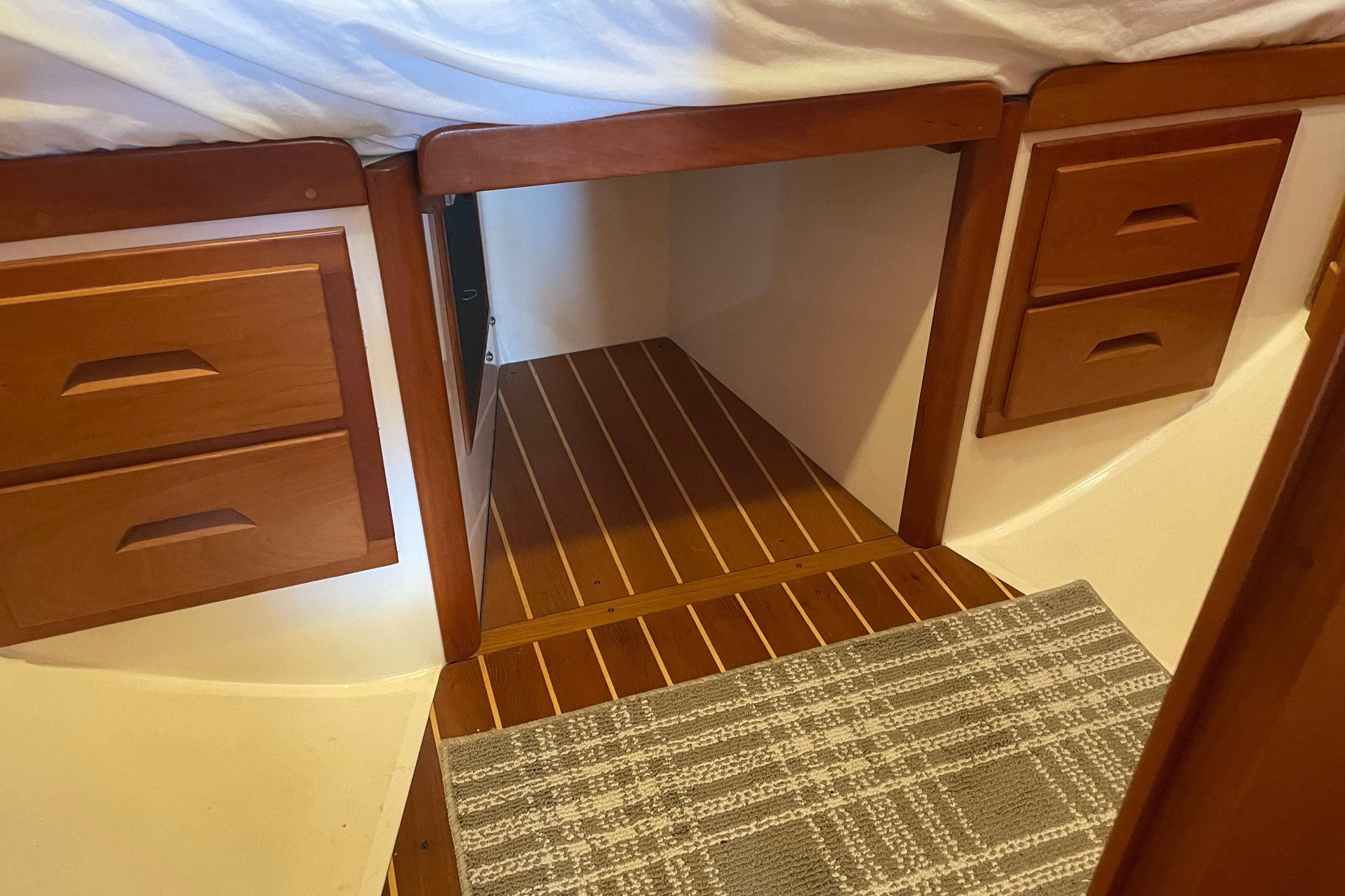 Interior of 2004 Tartan 3700 sailboat with wooden drawers and striped flooring.