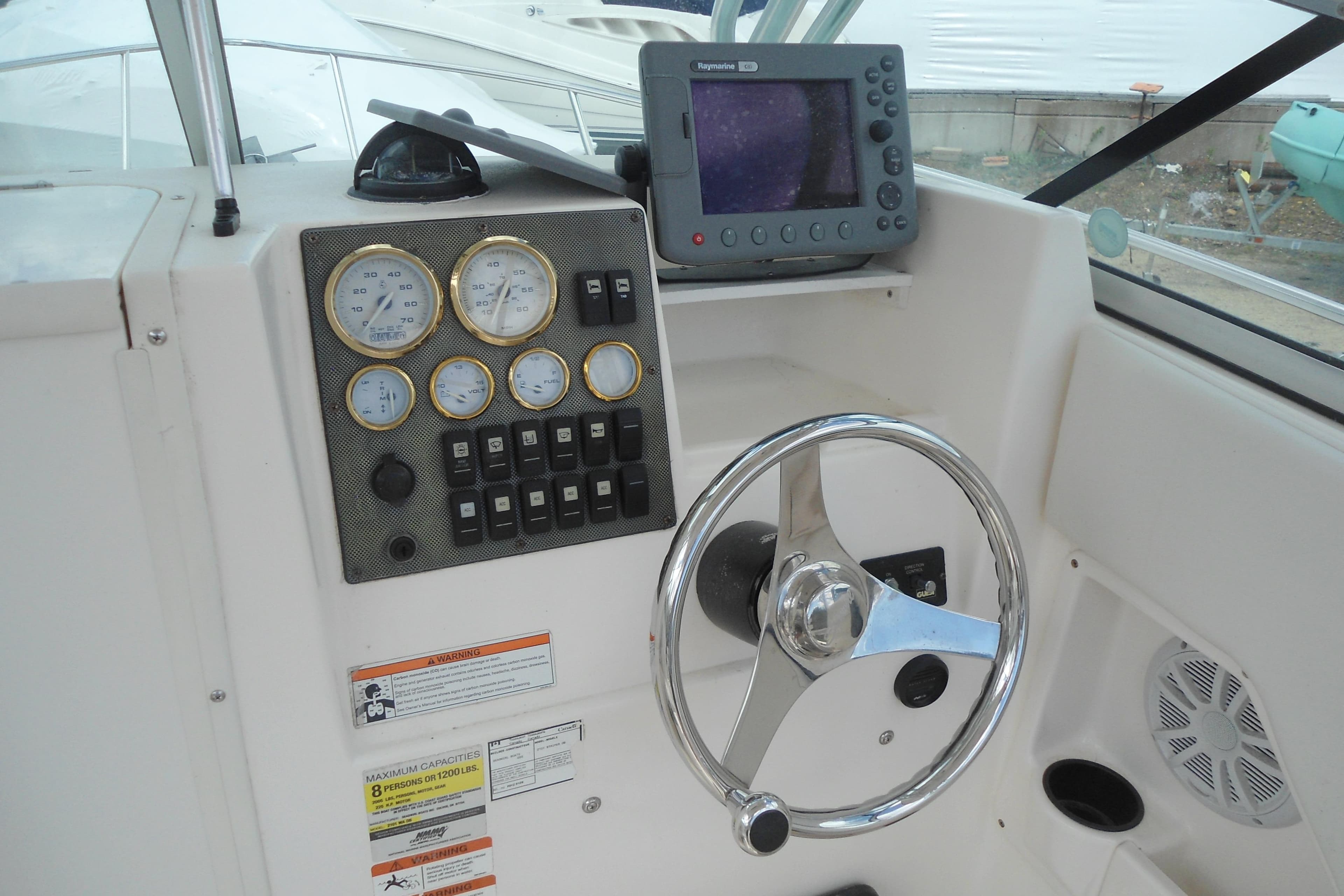 2008 Seaswirl Striper 2101 Walkaround OB helm with gauges, steering wheel, and navigation system.