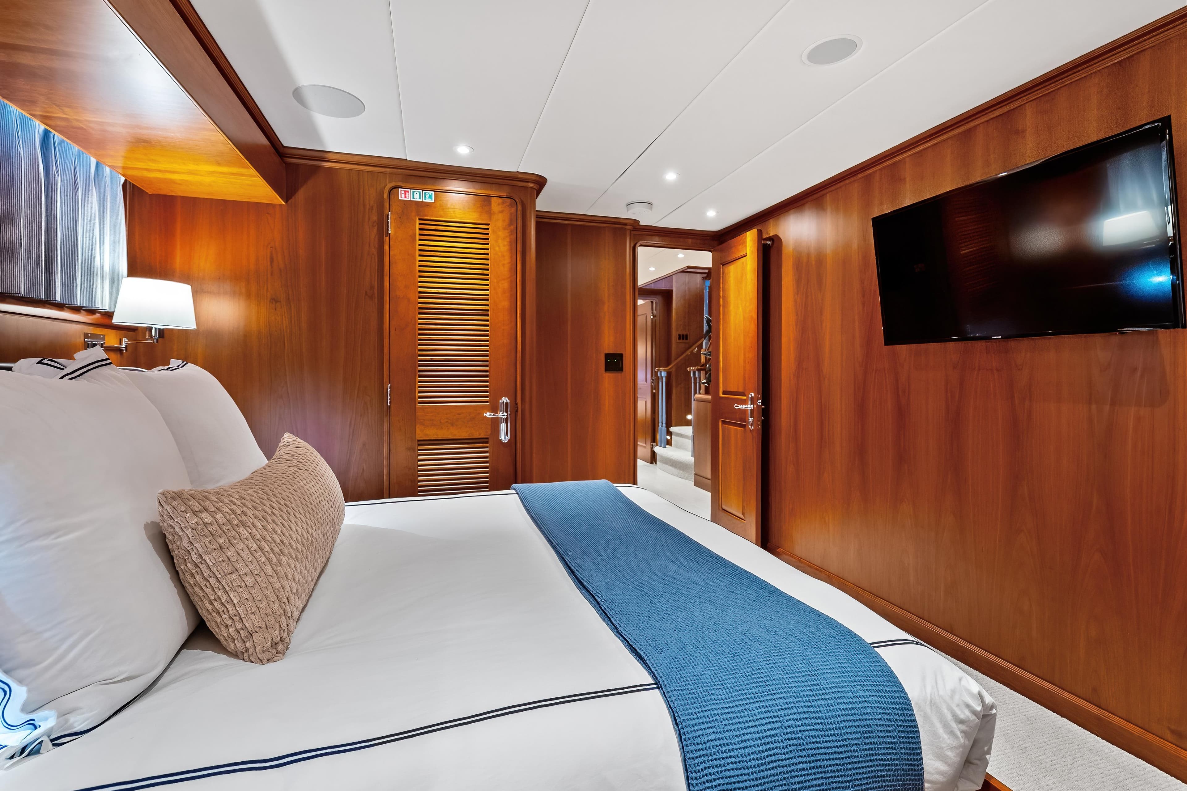 Luxurious cabin interior of 1998 Burger Raised Pilothouse yacht with wood paneling and modern amenities.