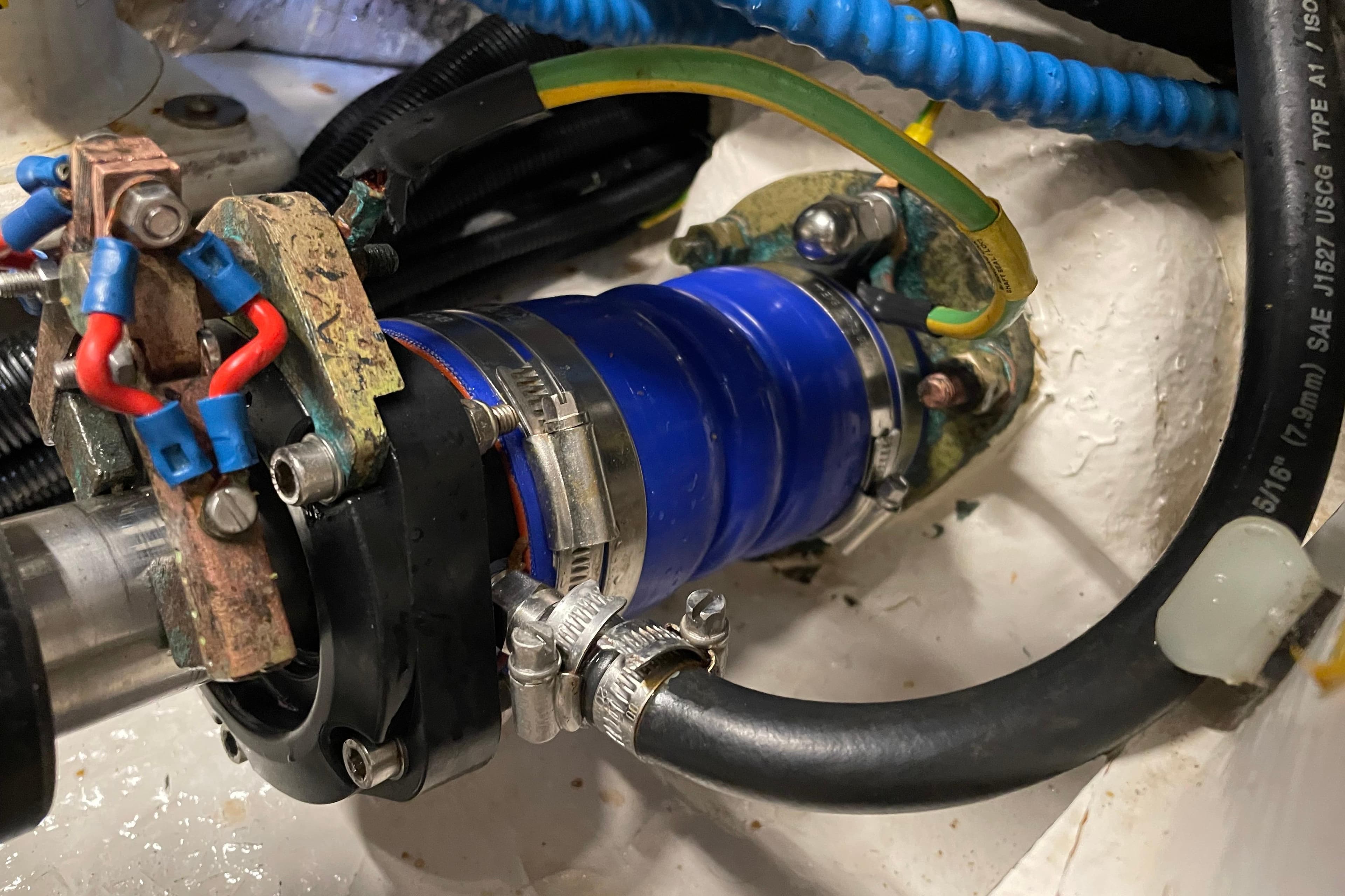 Close-up of a Moody 56 (2004) engine component with blue hose and wiring.