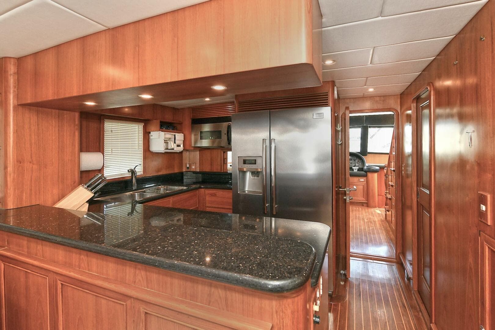 Luxurious 2002 Grand Alaskan Flushdeck yacht kitchen with wood cabinetry and modern appliances.