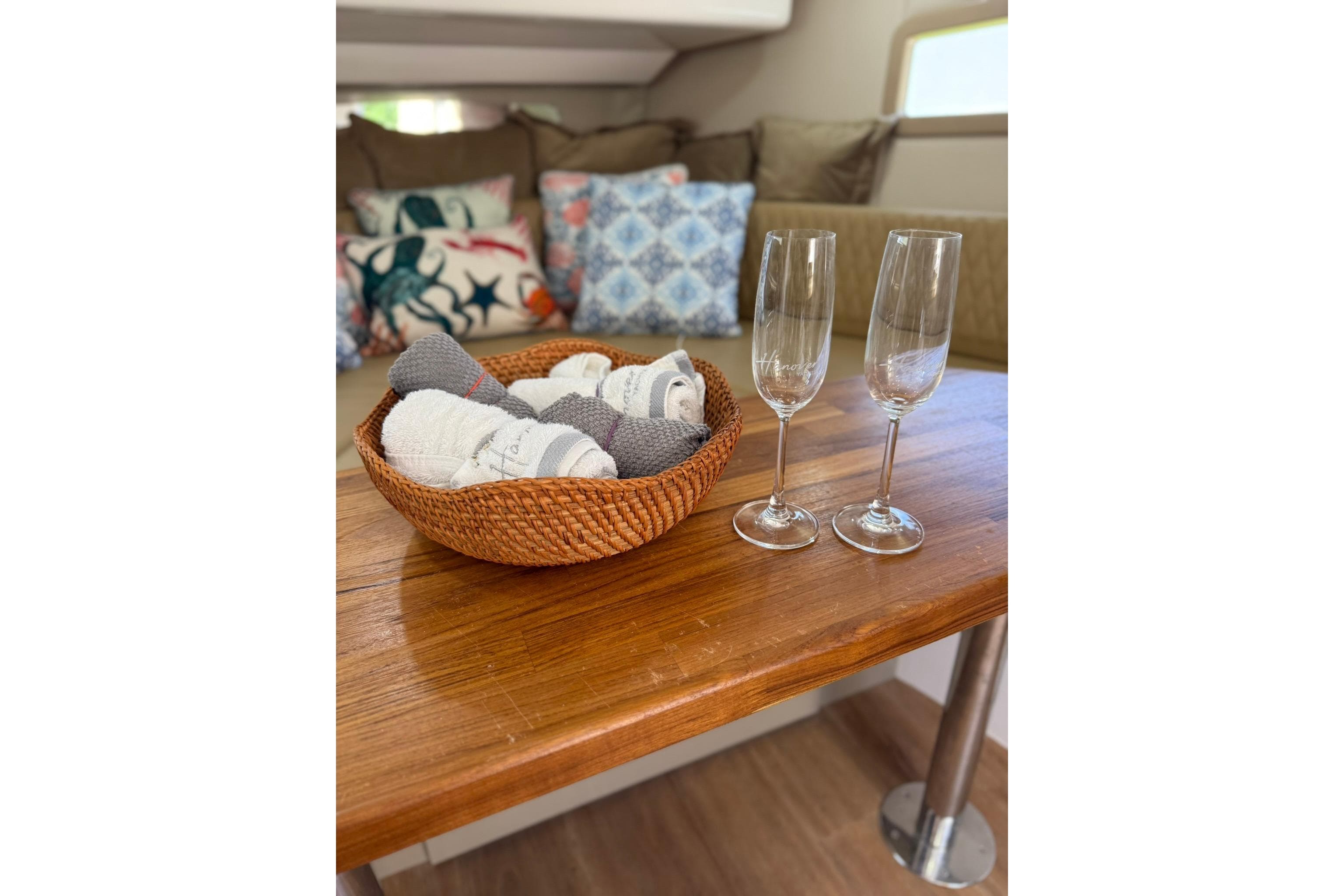 Cozy interior of 2024 Hanover 387 with basket and champagne glasses on wooden table.