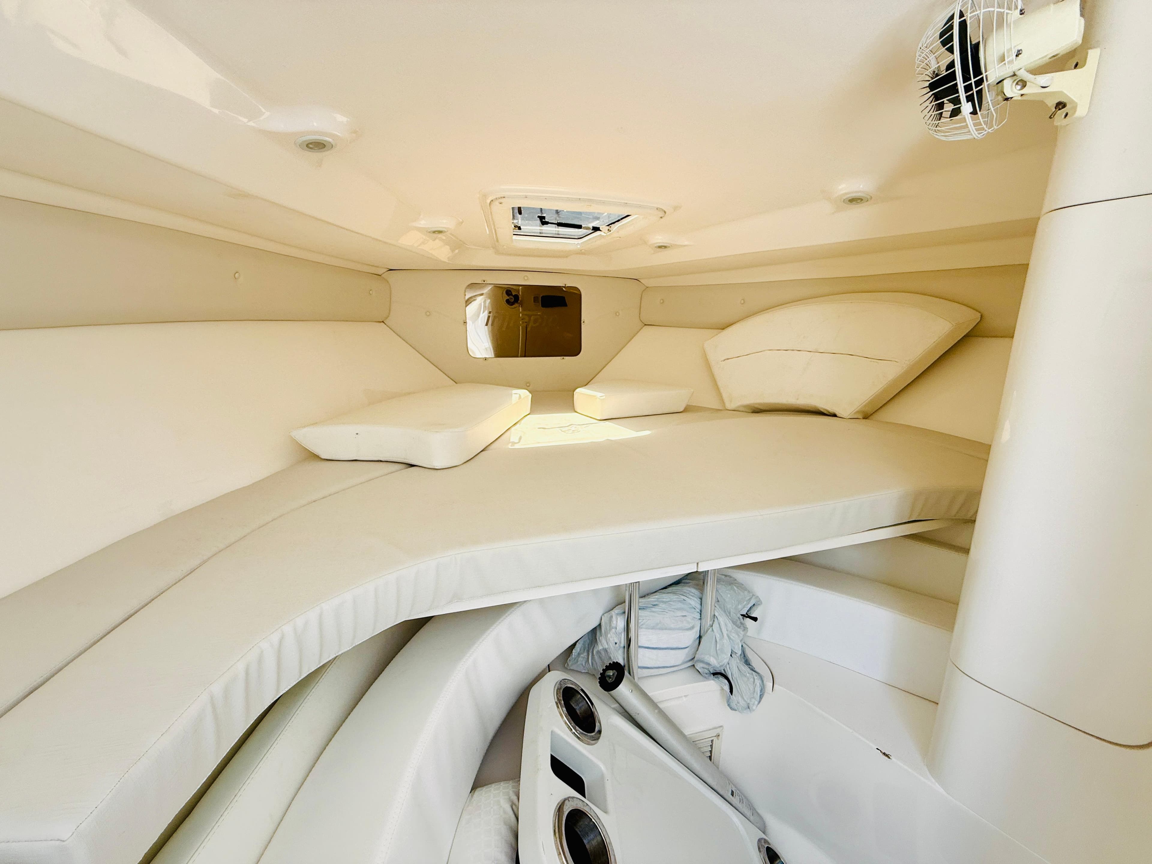 2003 Intrepid 377 cabin interior with white cushioned seating and storage compartments.