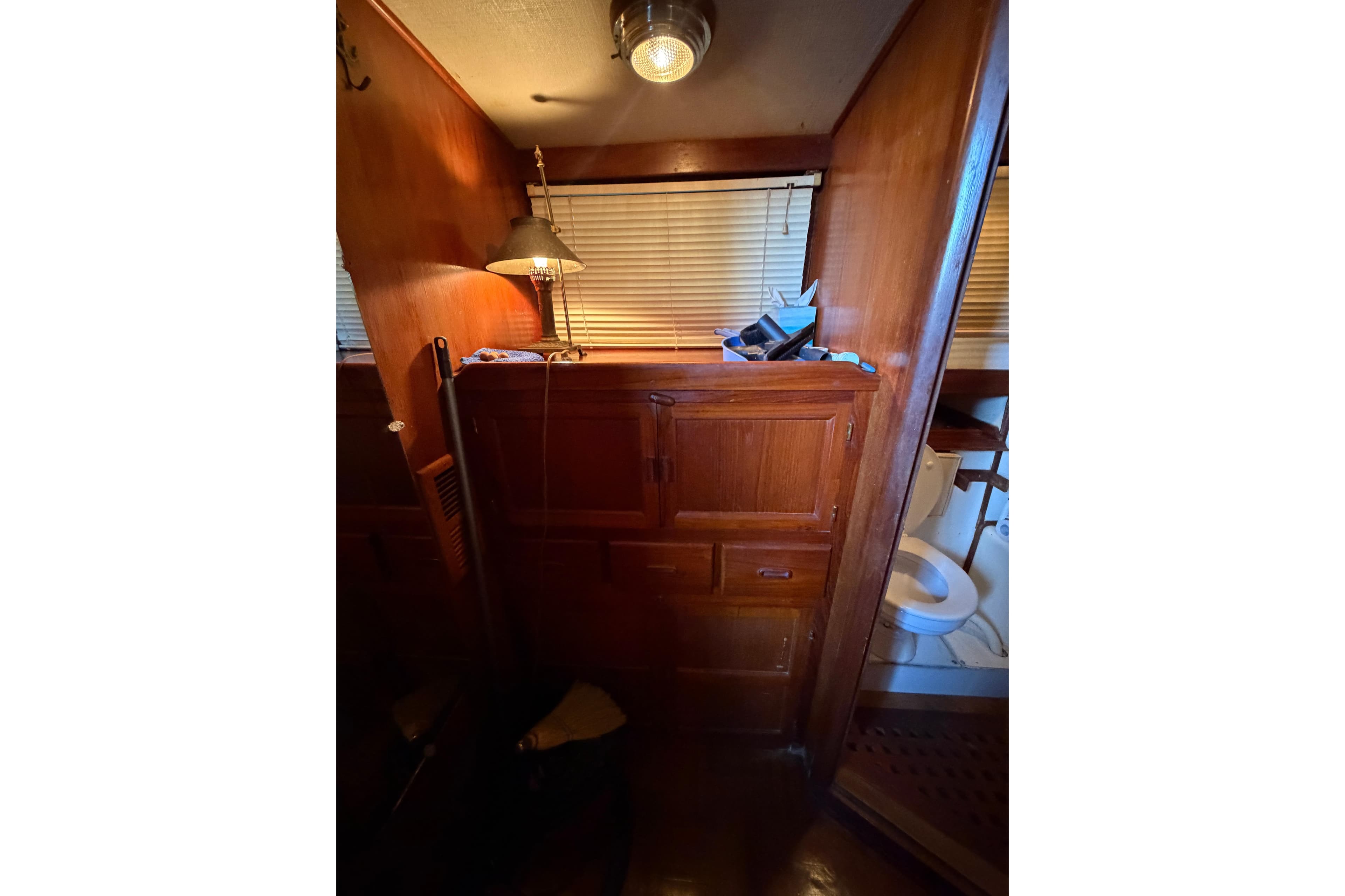 Interior of 1978 Albin 36 Trawler with wooden cabinetry and a small bathroom.