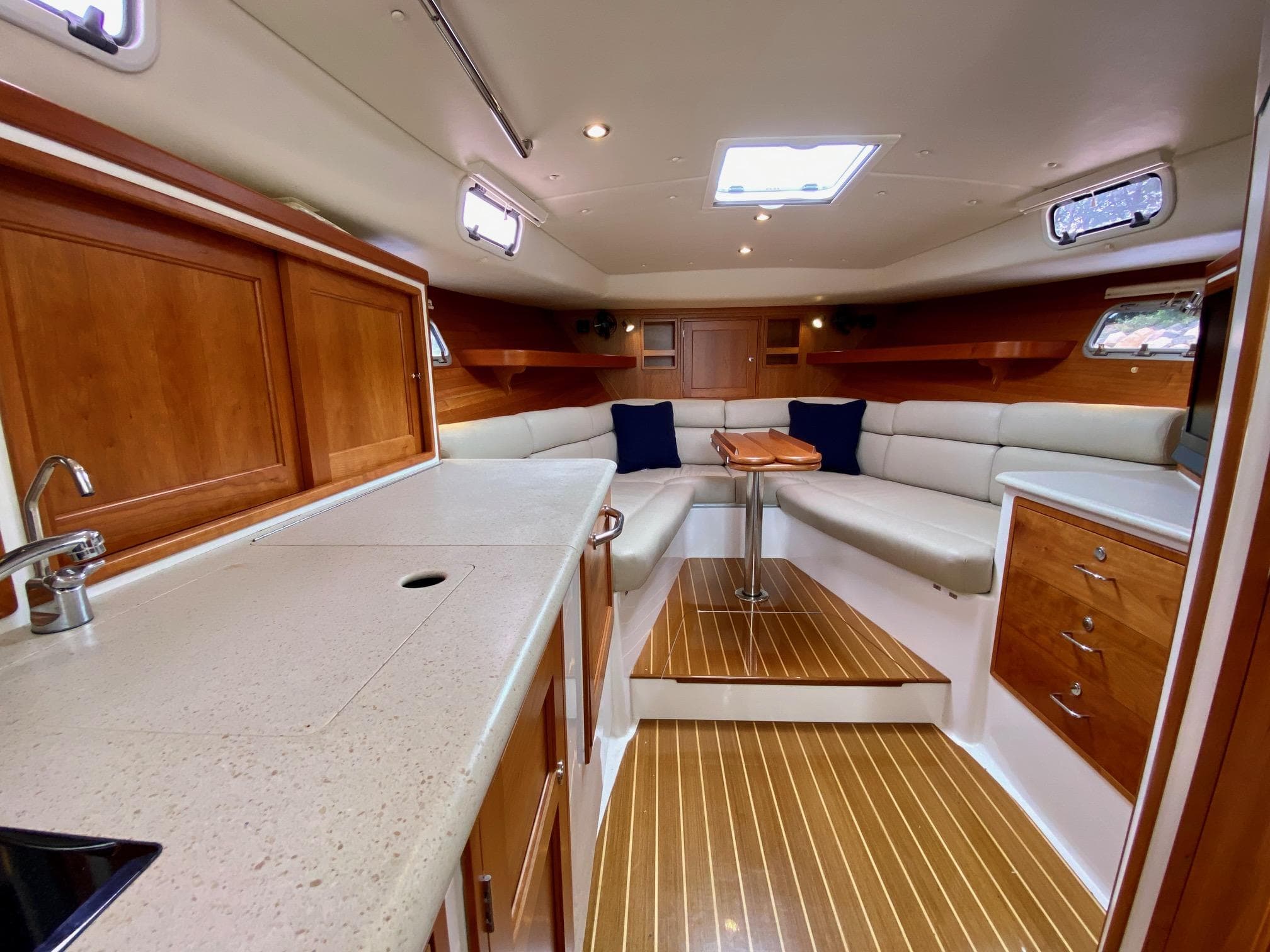 Luxurious interior of 2013 MJM 36z Downeast yacht with elegant wood finishes and cozy seating.