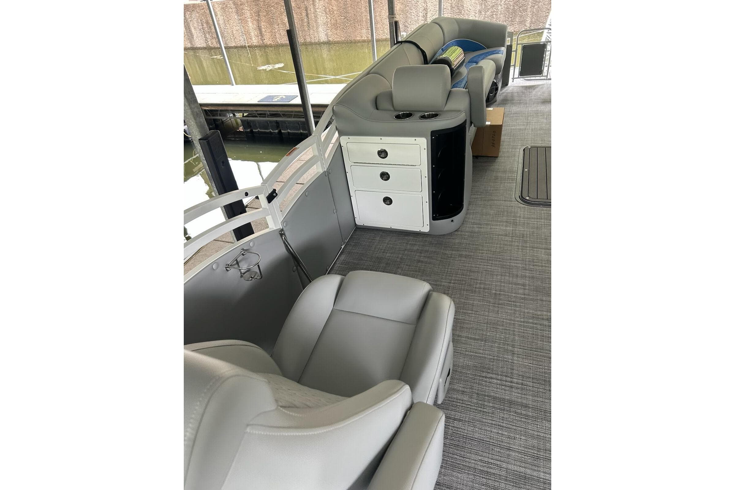 Interior of 2025 JC NEPTOON 27TT SPORT boat with gray seating and storage compartments.