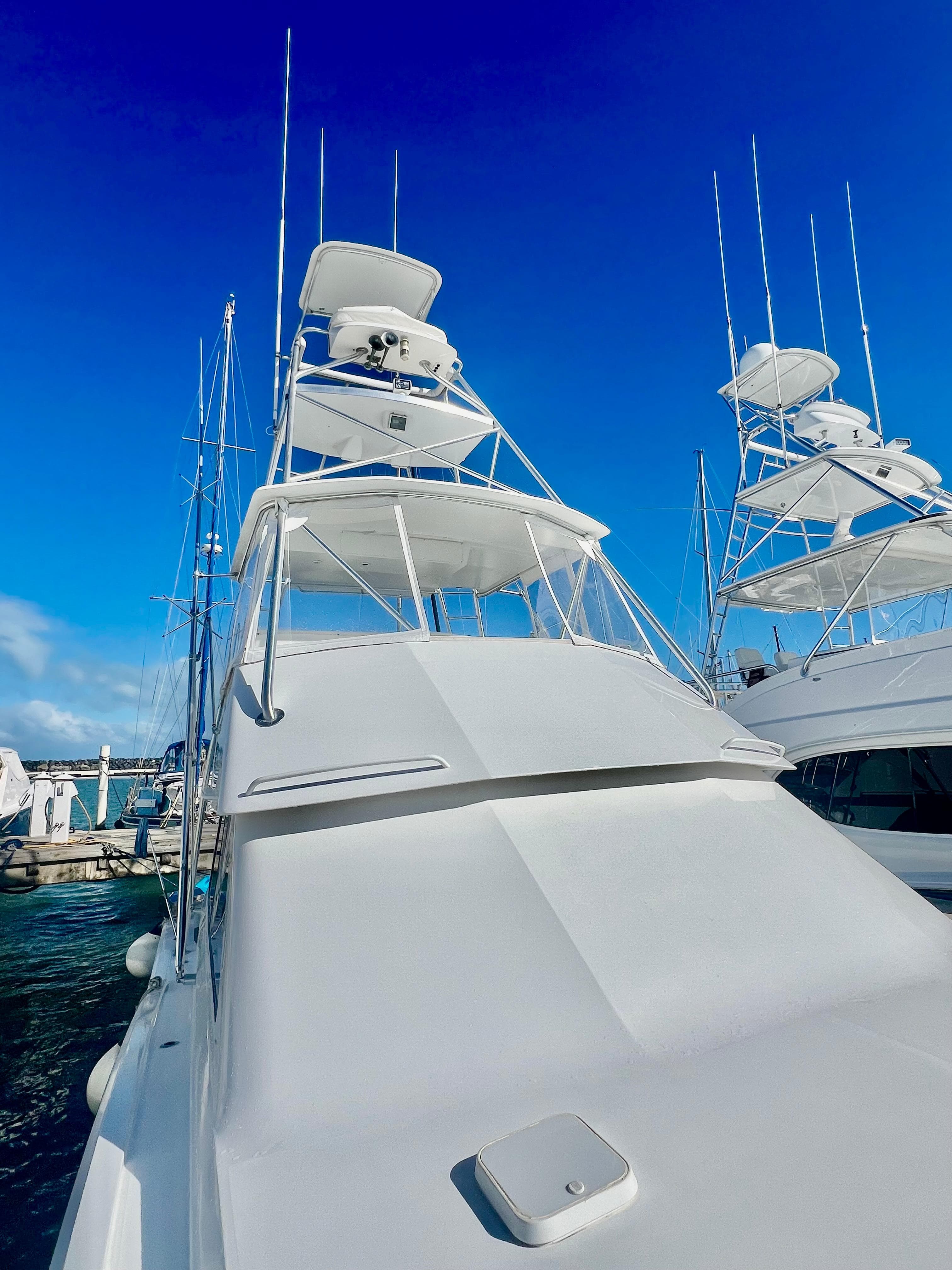 1997 Viking 43 Convertible yacht docked at marina under clear blue sky.