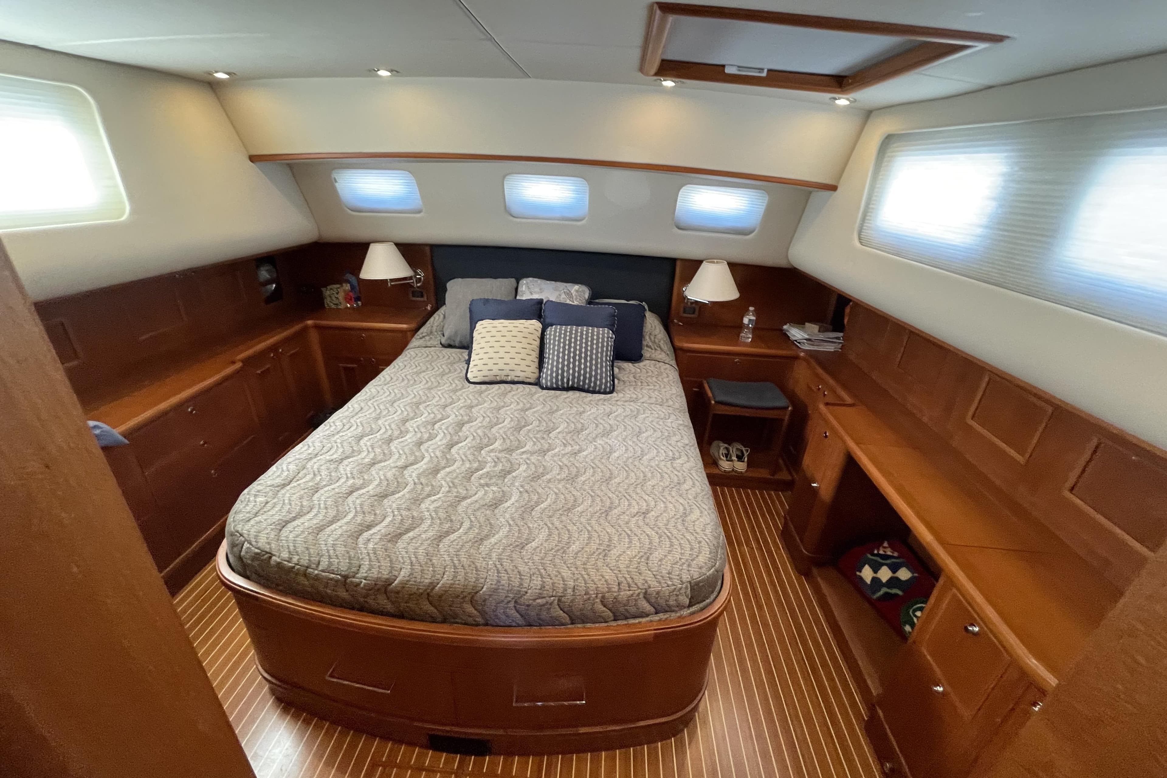 Luxurious cabin interior of 2007 Grand Banks 47 Heritage CL yacht with cozy bed and wooden furnishings.