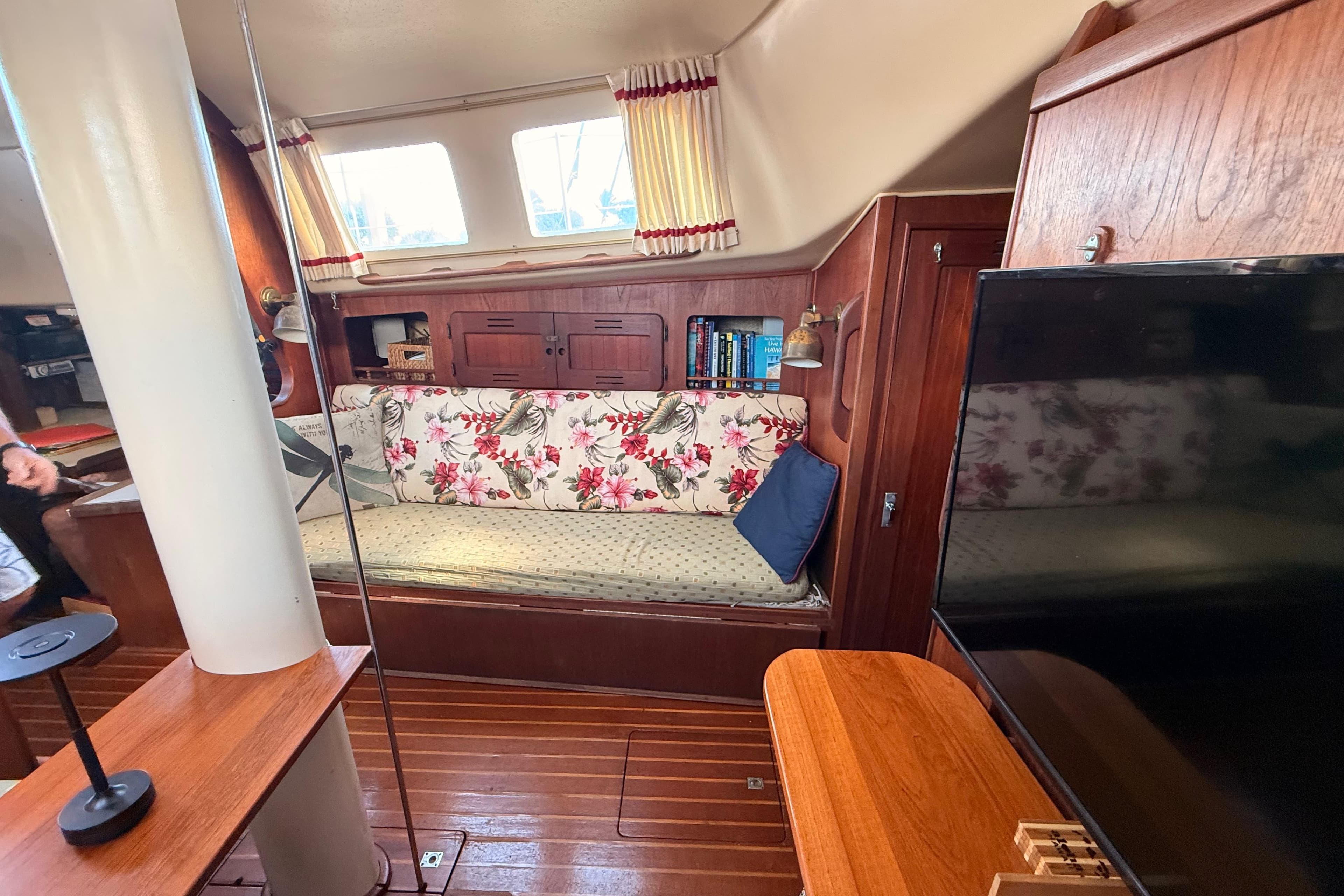 Interior of a 1978 Morgan 452 sailboat with floral upholstery and wooden furnishings.