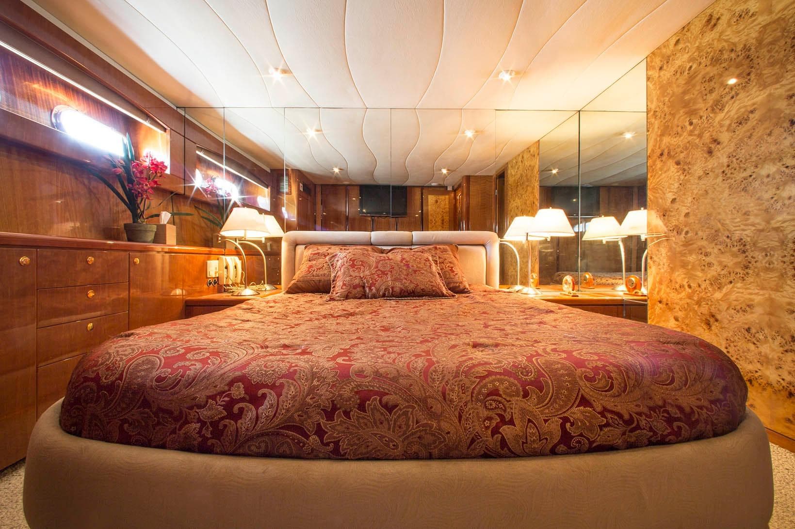 Luxurious bedroom interior of 1996 Hershine Benship 87 yacht with elegant decor and ambient lighting.
