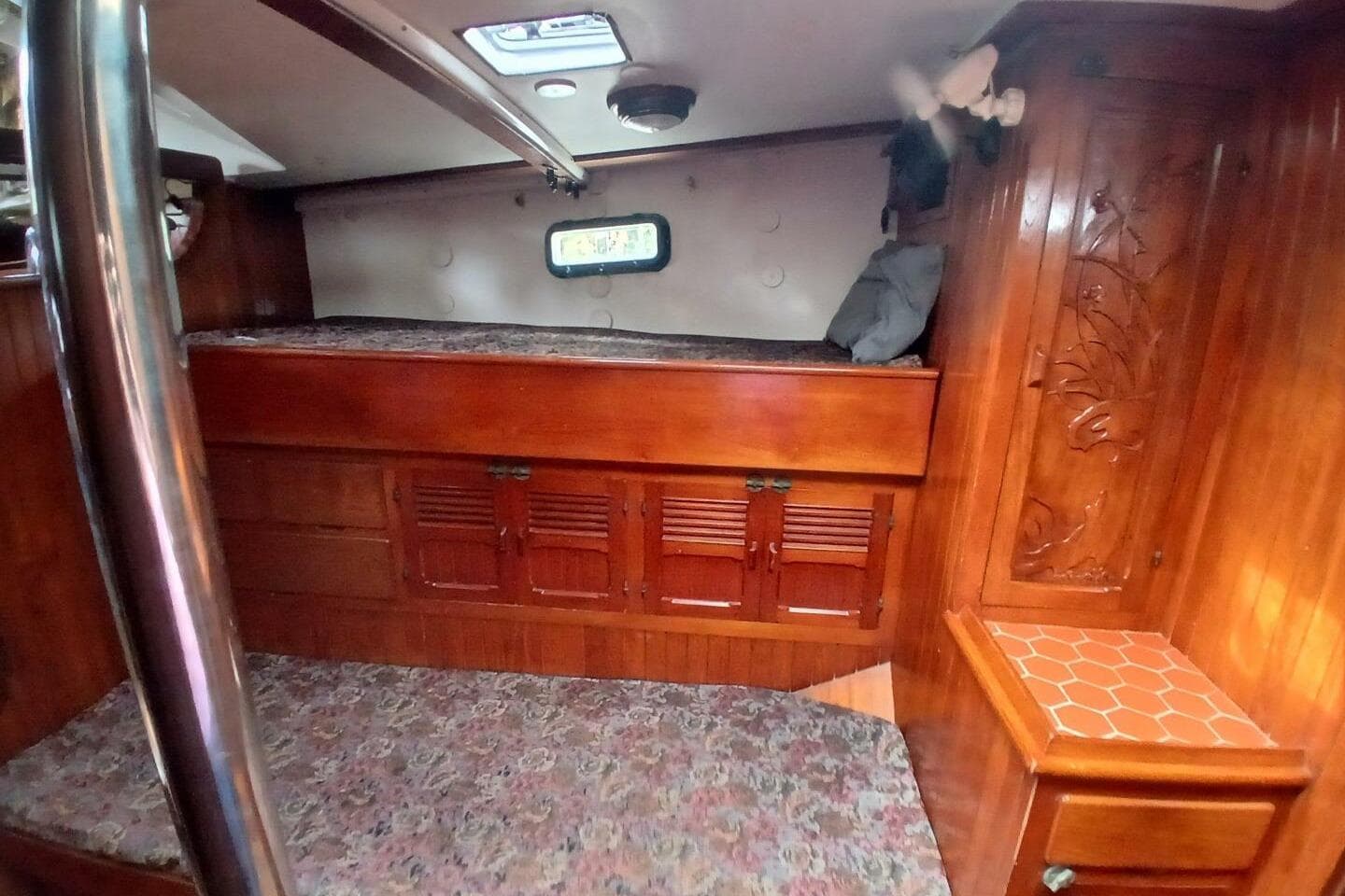 Cozy 1980 Hardin 45 yacht cabin with wooden interior and built-in storage.