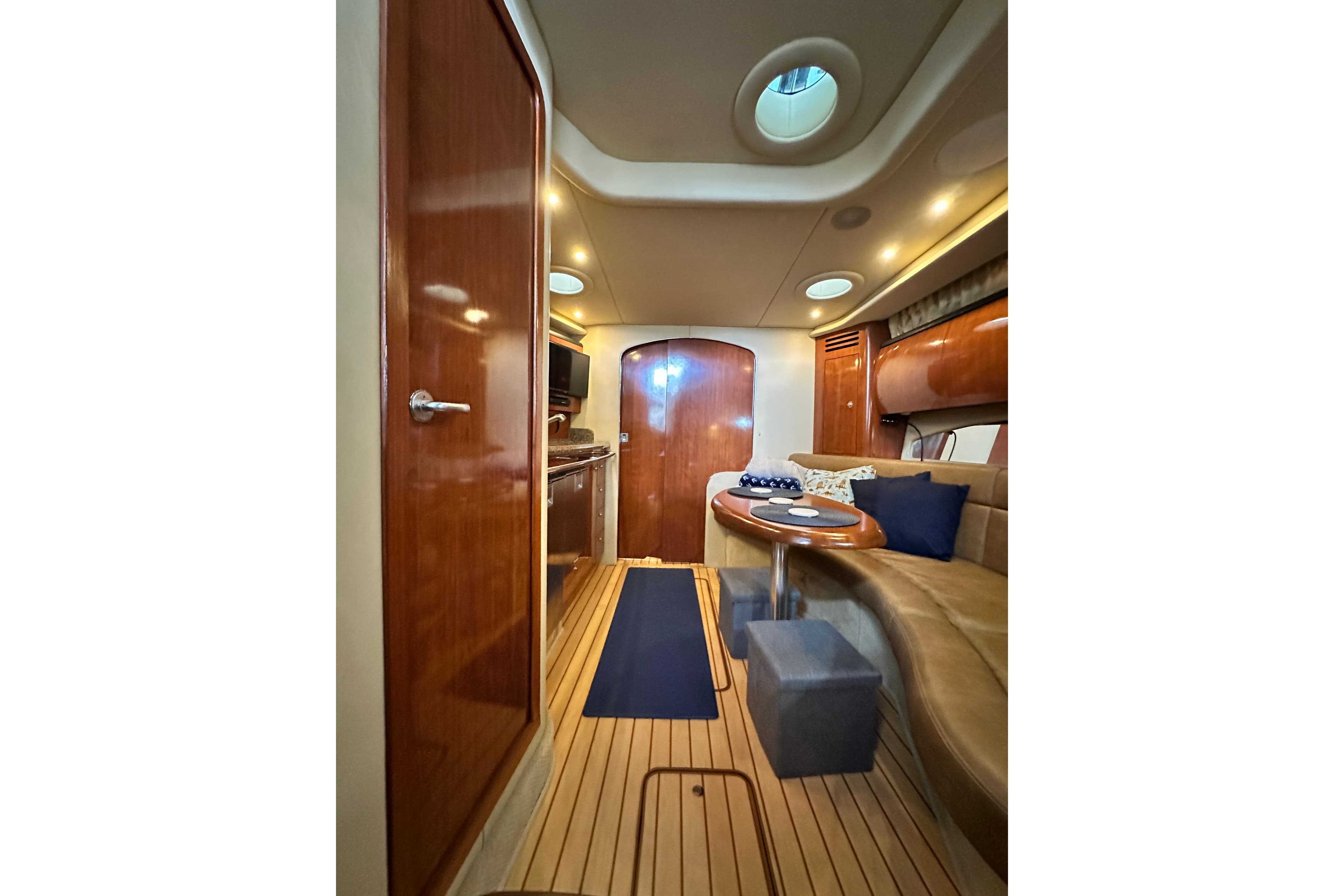 Interior of 2005 Sea Ray 360 Sundancer yacht with wood finishes and cozy seating area.