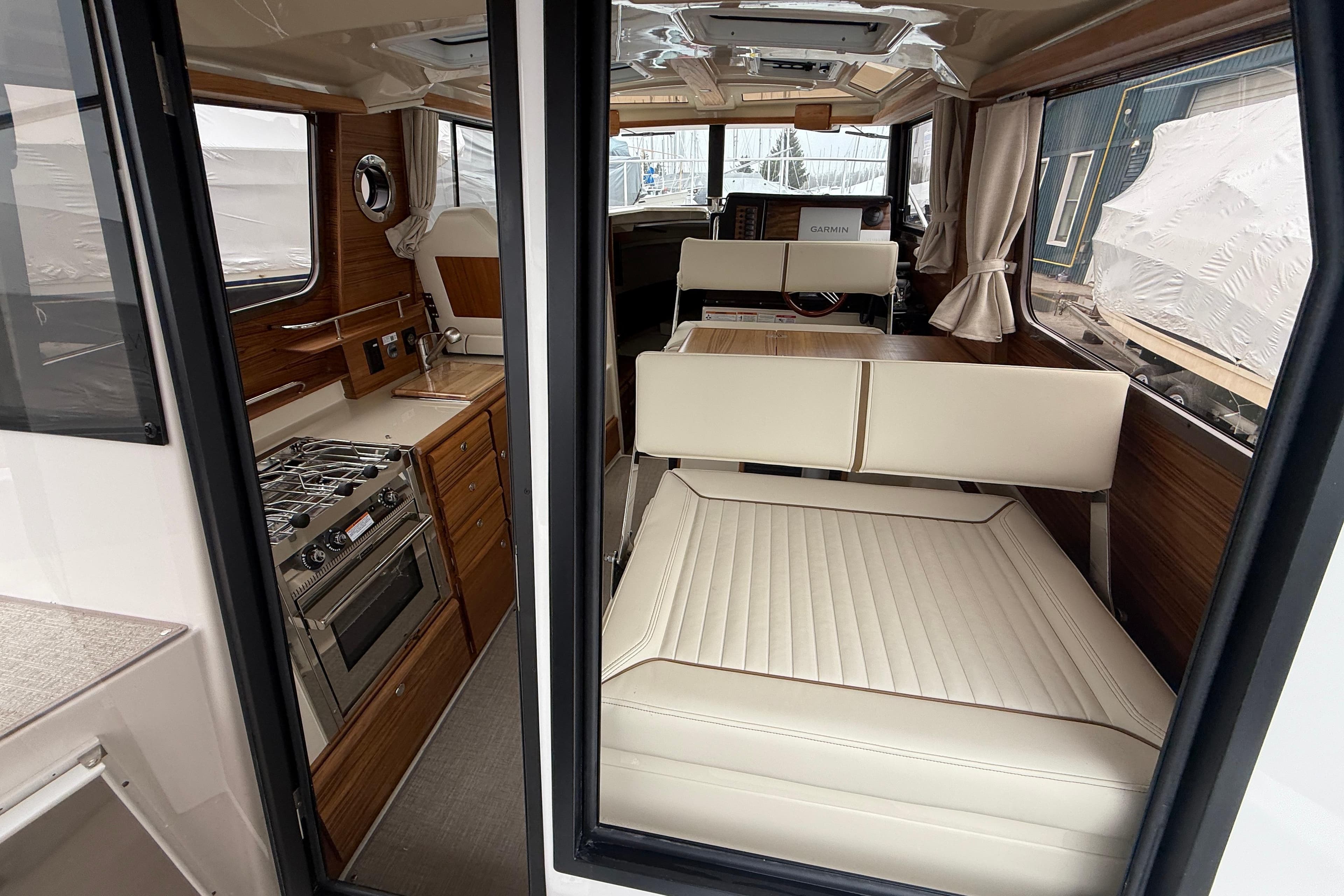 Interior of 2026 Ranger Tugs R-27 boat with kitchen and seating area.