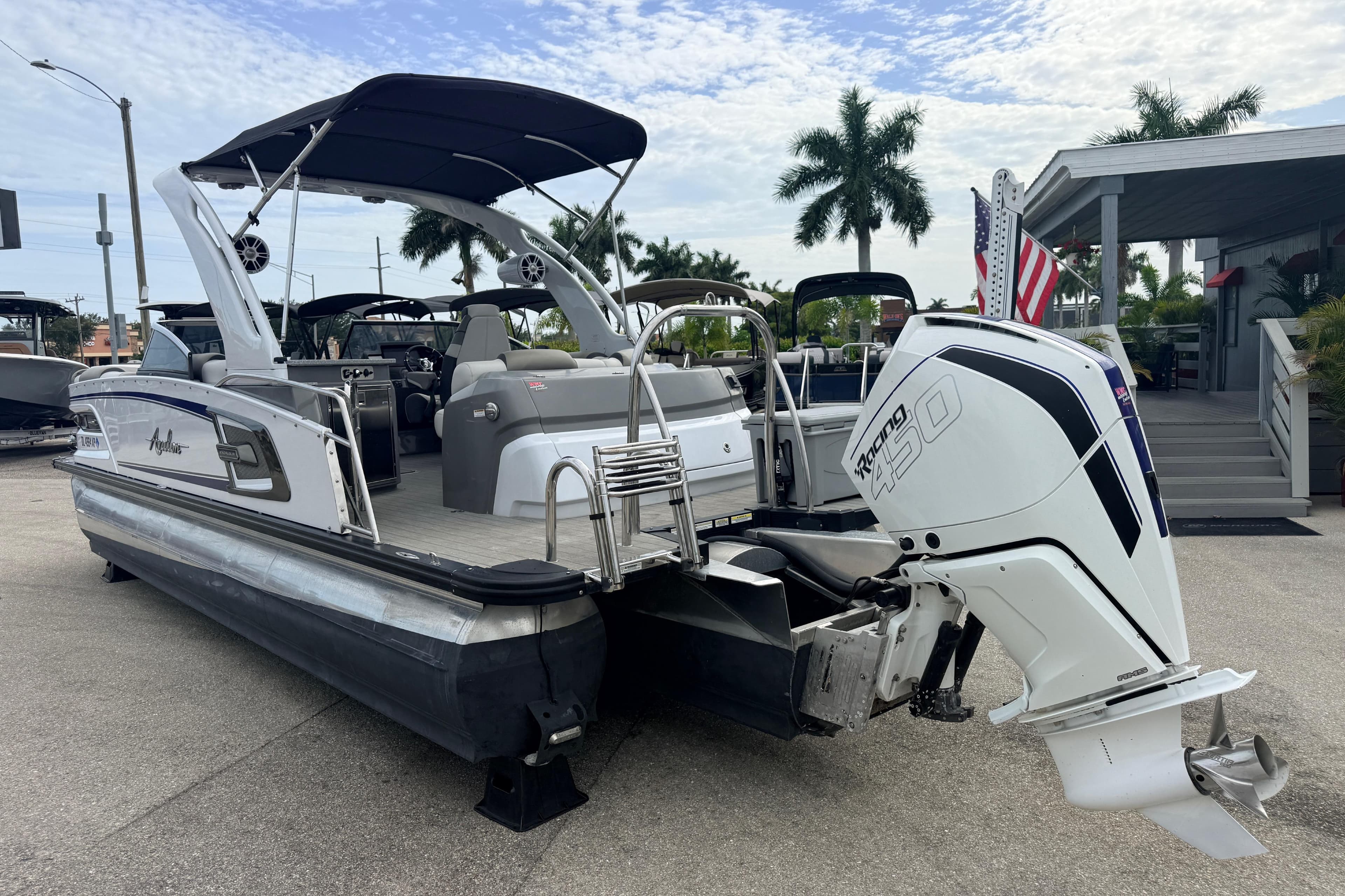2023 Avalon Excalibur 2585 Windshield Elite Tri Toon with Single 450R engine, docked outdoors.